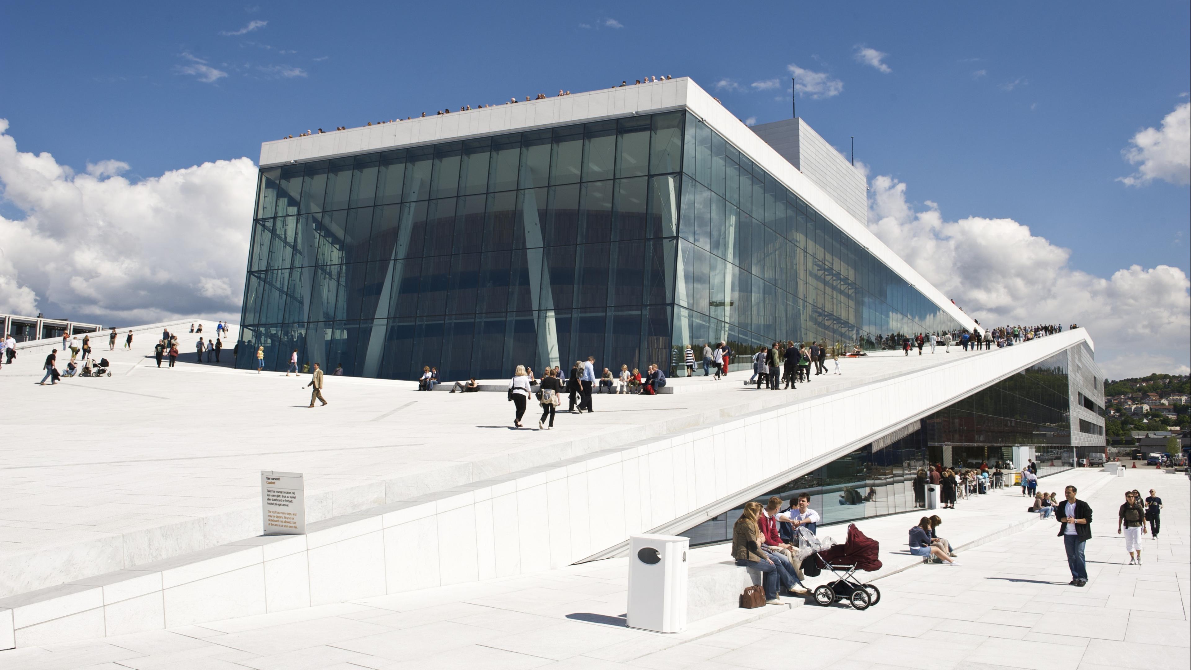 Menschen begehen eine schräge Fläche des Opernhauses in Oslo