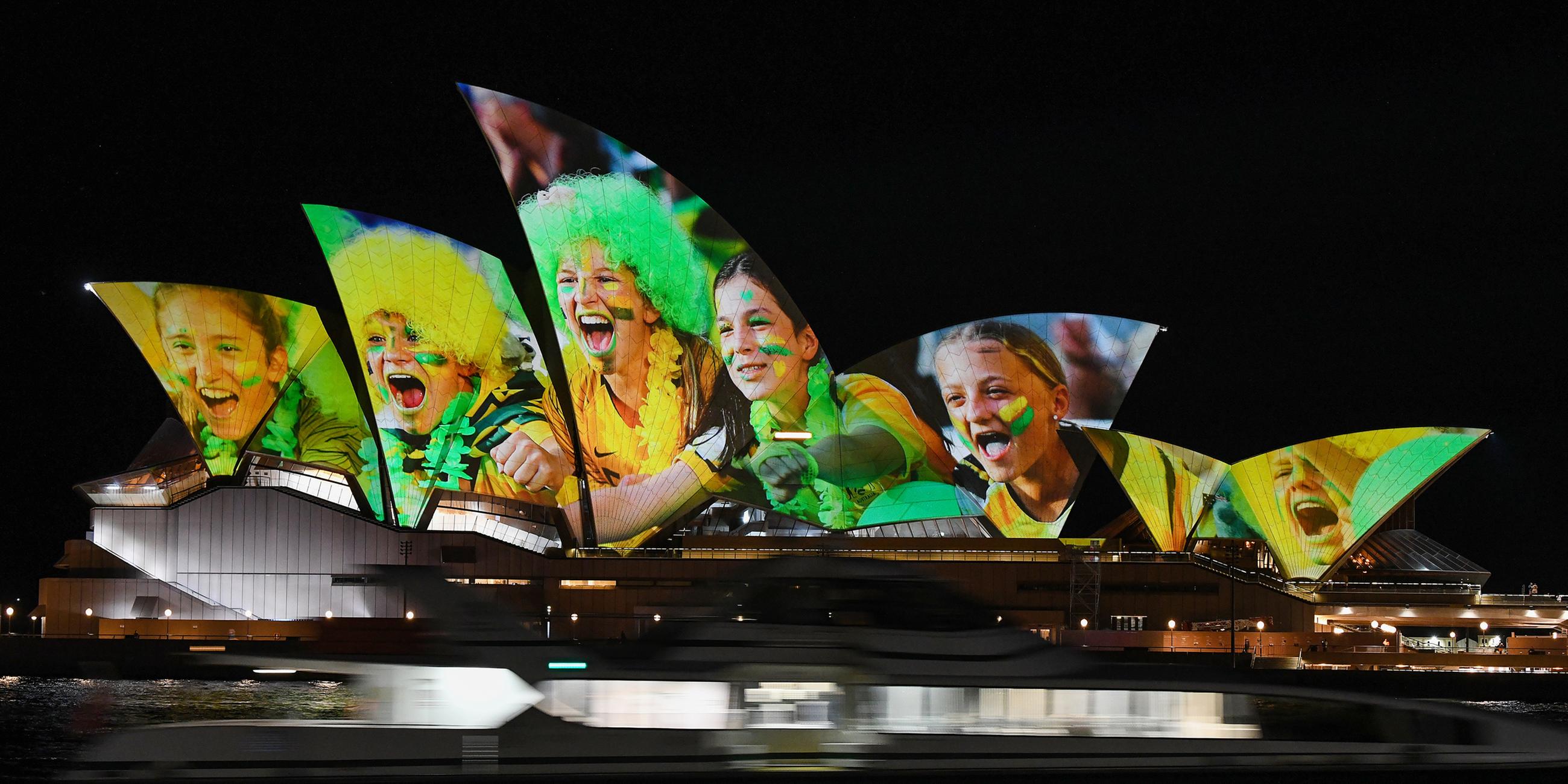 Das Opernhaus ist mit leuchtenden bunten Fotos von Fußball-Fans angestrahlt, um auf die beiden Austragungsorte der Frauenfußball-WM 2023 hinzuweisen: Australien und Neuseeland.