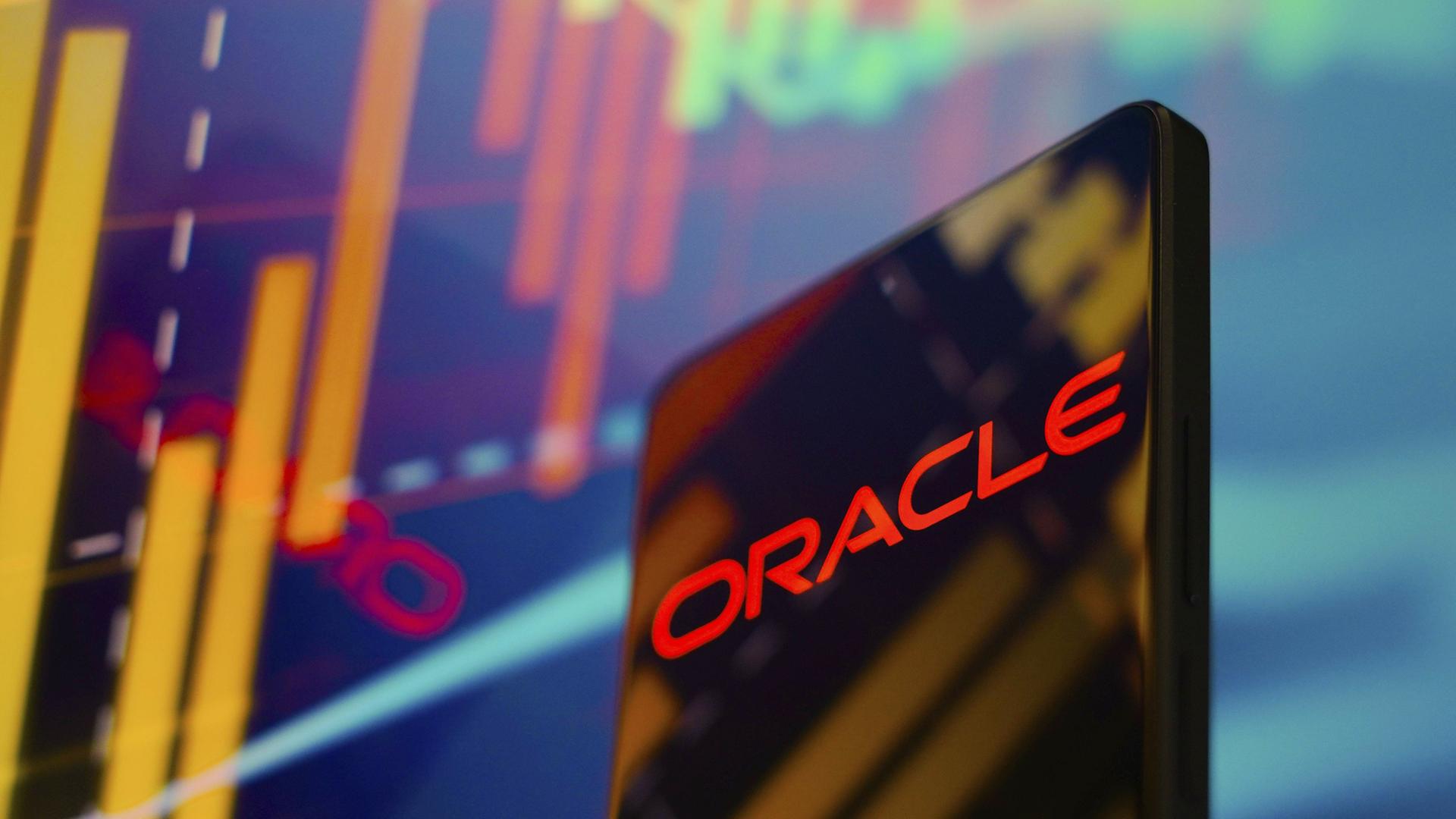 Auf einem Smartphone ist in Rot auf Schwarz das Wort Oracle zu sehen. Im Hintergrund sind bunte digitale Schemata zu sehen.