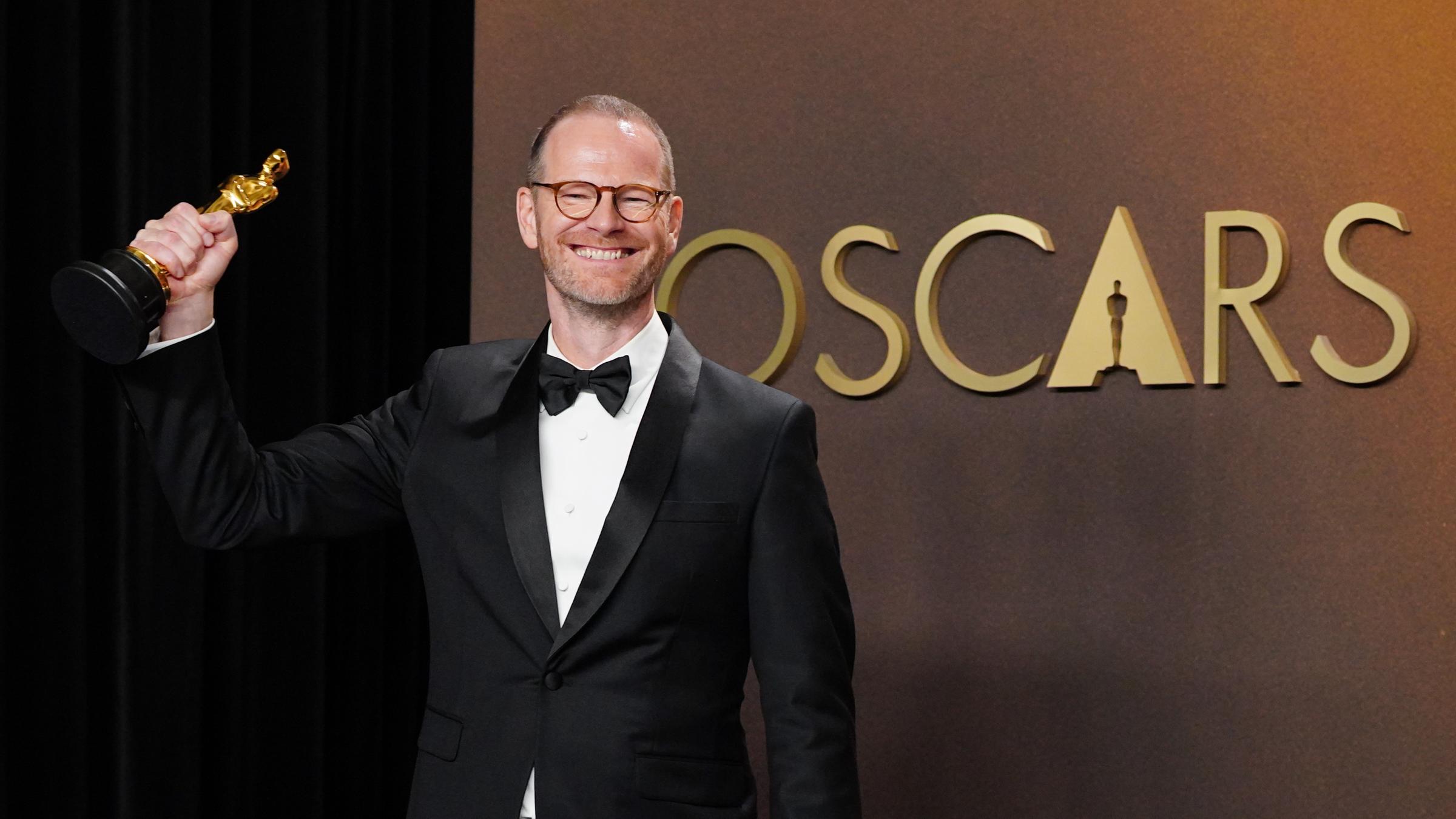 Joachim Trier, Regisseur "Sentimental Value," mit dem Oscar vor dem Schriftzug Oscars