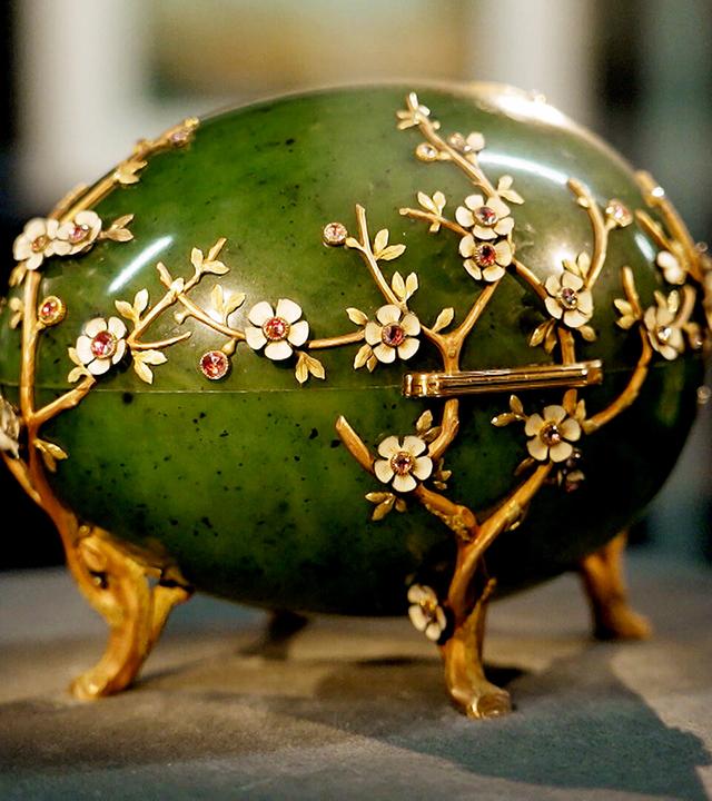 Ein günes Ei mit goldenen Blütenranken. 