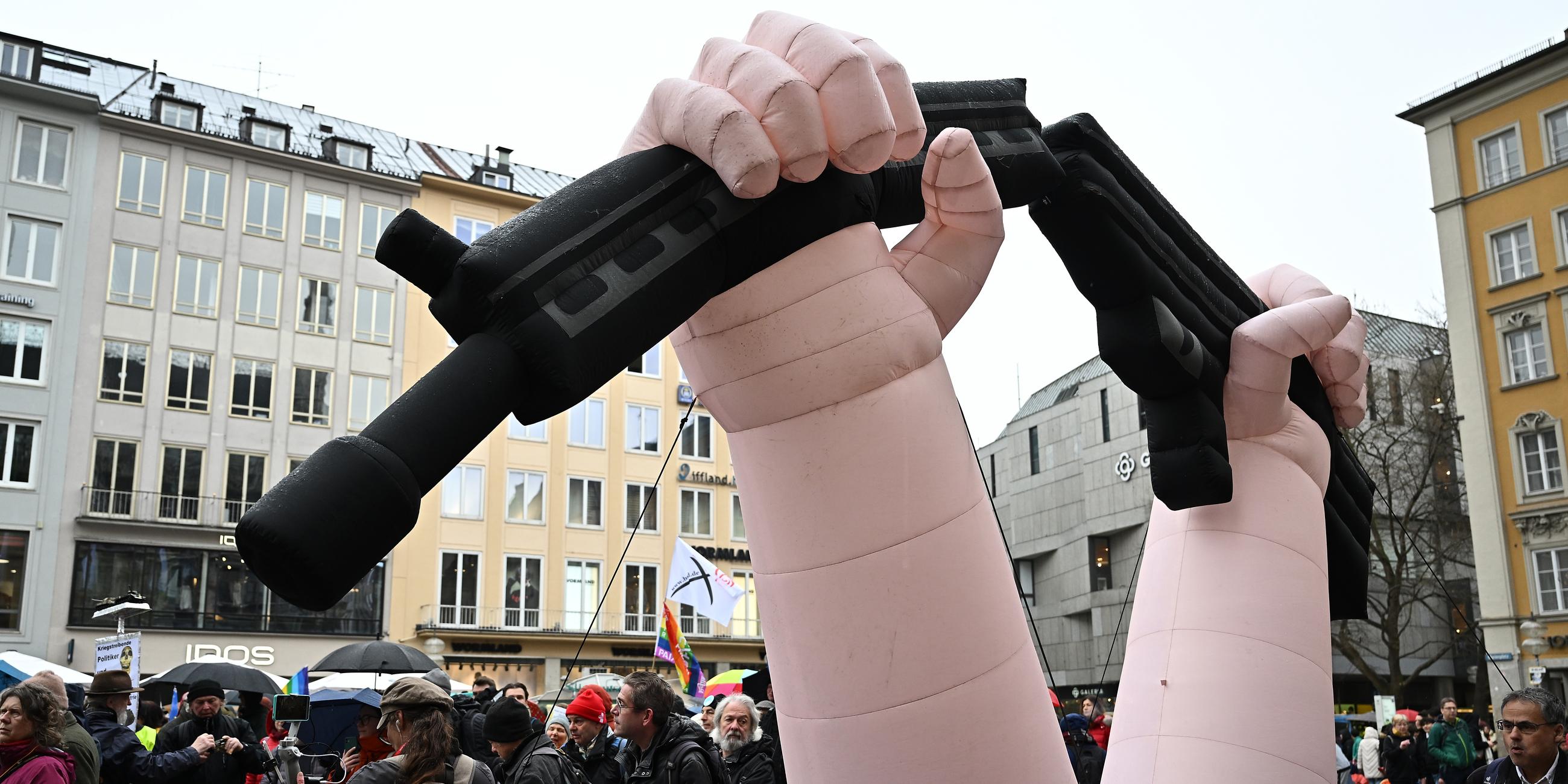 Ein aufblasbares Transparent, das zwei Hände zeigt, die ein Gewehr zerbrechen, ist während der Auftaktkundgebung zum Ostermarsch zu sehen.