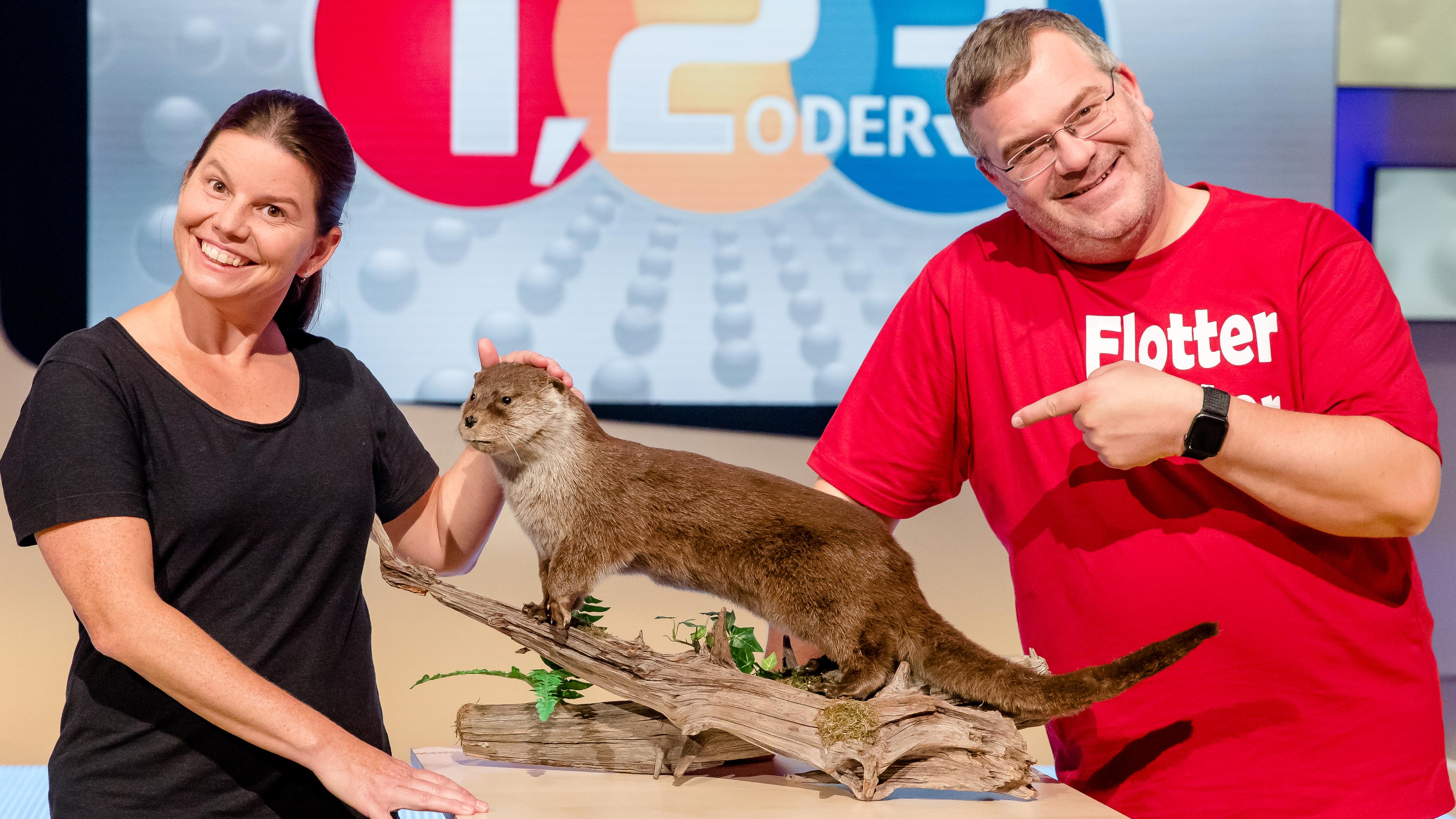 Elton und Biologin Dr. Irene Weinberger stehen lächelnd neben einem ausgestopften Otter.