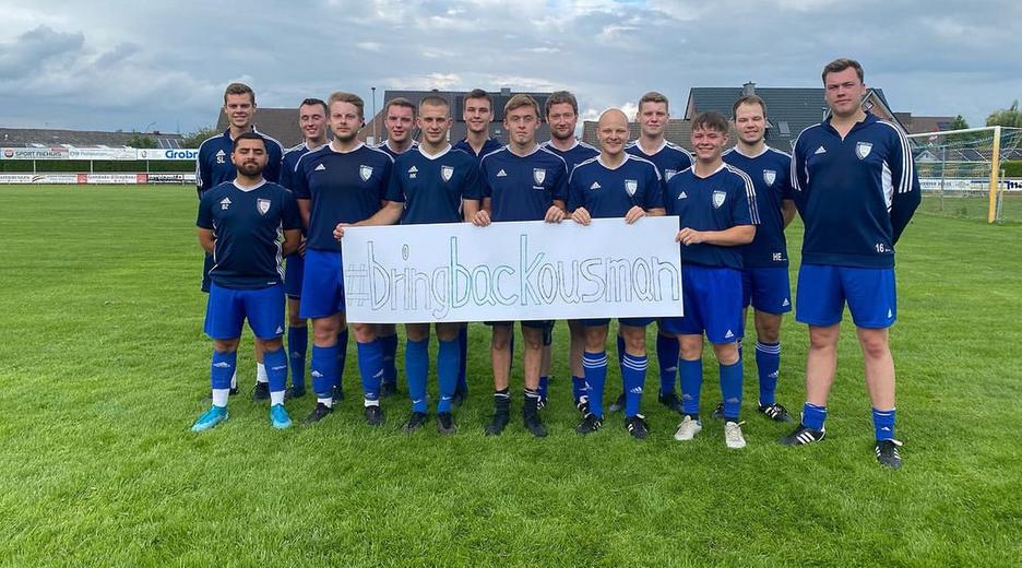 Die Spieler des 1.FC Ottenstein halten ein Plakat hoch mit der Aufschrift #bringbackousman