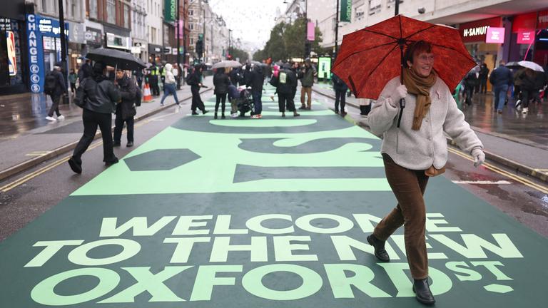 Menschen gehen auf der ehemaligen Fahrbahn der Oxford Street in London, Großbritannien.