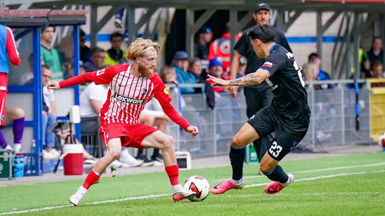 Freiburgs Flügelspieler Niklas Beste versucht, seinen Paderborner Gegenspieler Raphael Obermair im Zweikampf ins Leere laufen zu lassen.