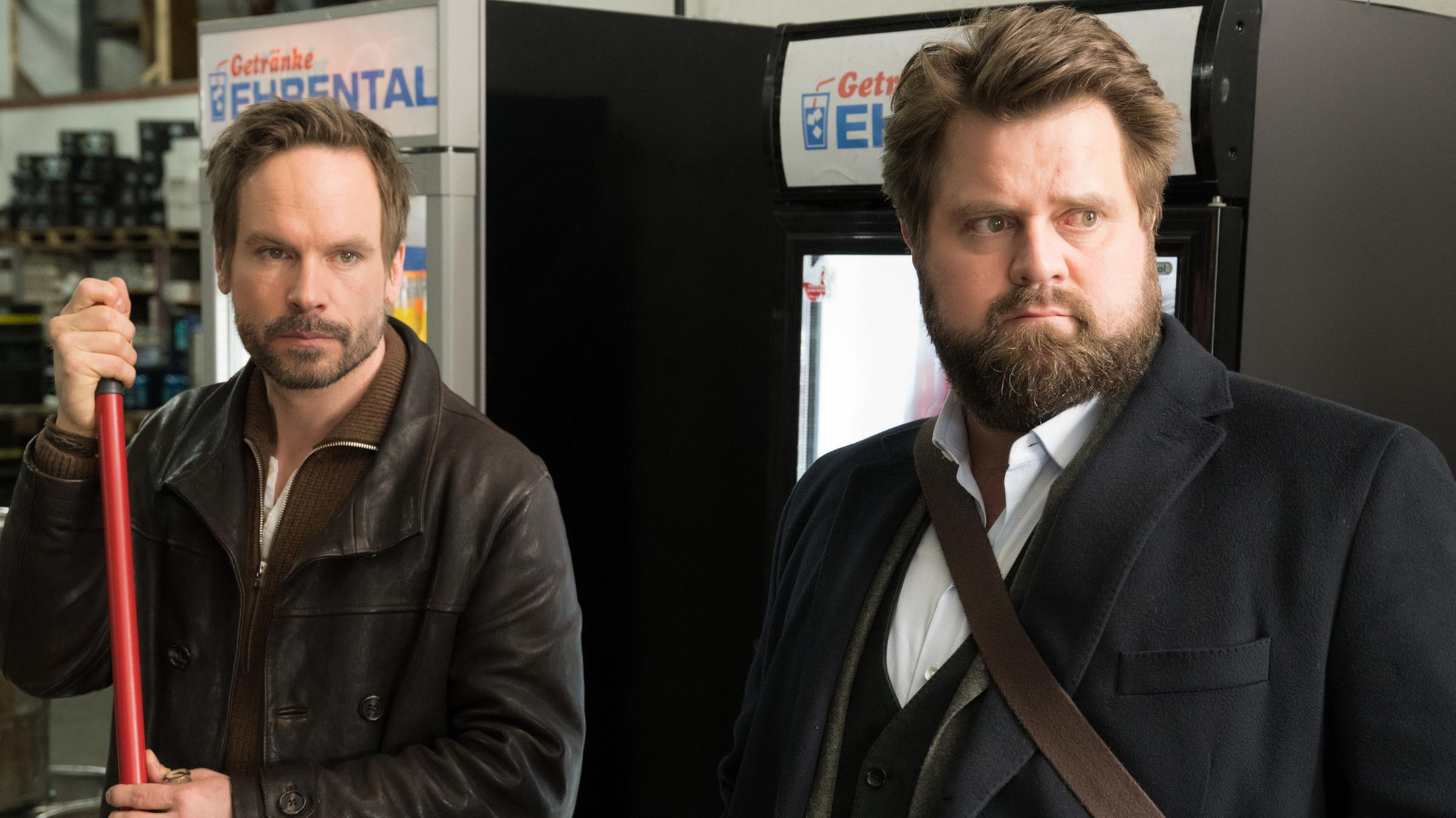 Leo Oswald (Wanja Mues) und Benni Hornberg (Antoine Monot, Jr.) stehen im Getränkelager und schauen aufmerksam Richtung Ausgang.