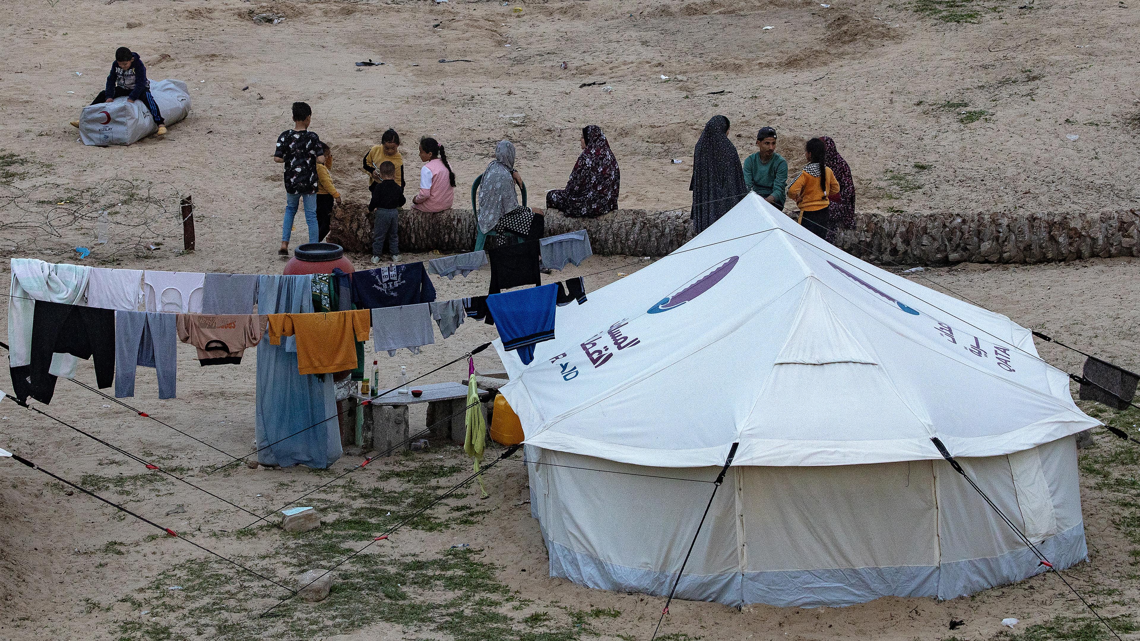 Vertriebene Palästinenser sitzen neben ihrem Zelt am Strand nahe der Grenze zwischen dem Gazastreifen und Ägypten im Flüchtlingslager Rafah, südlicher Gazastreifen, aufgenommen am 13.02.2024