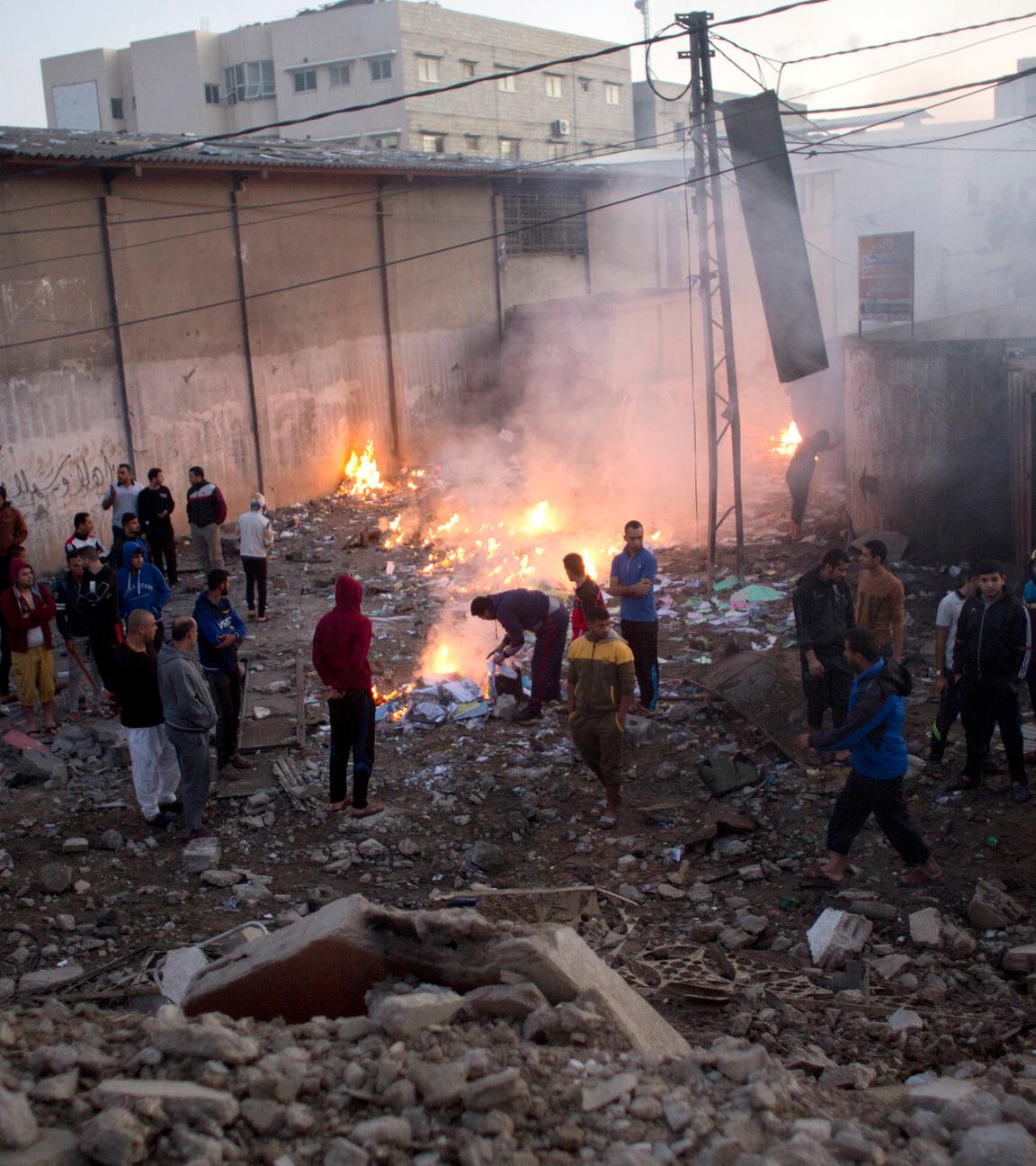 Palästinenser stehen zwischen Häusertrümmern nach einem Angriff des israelischen Militärs