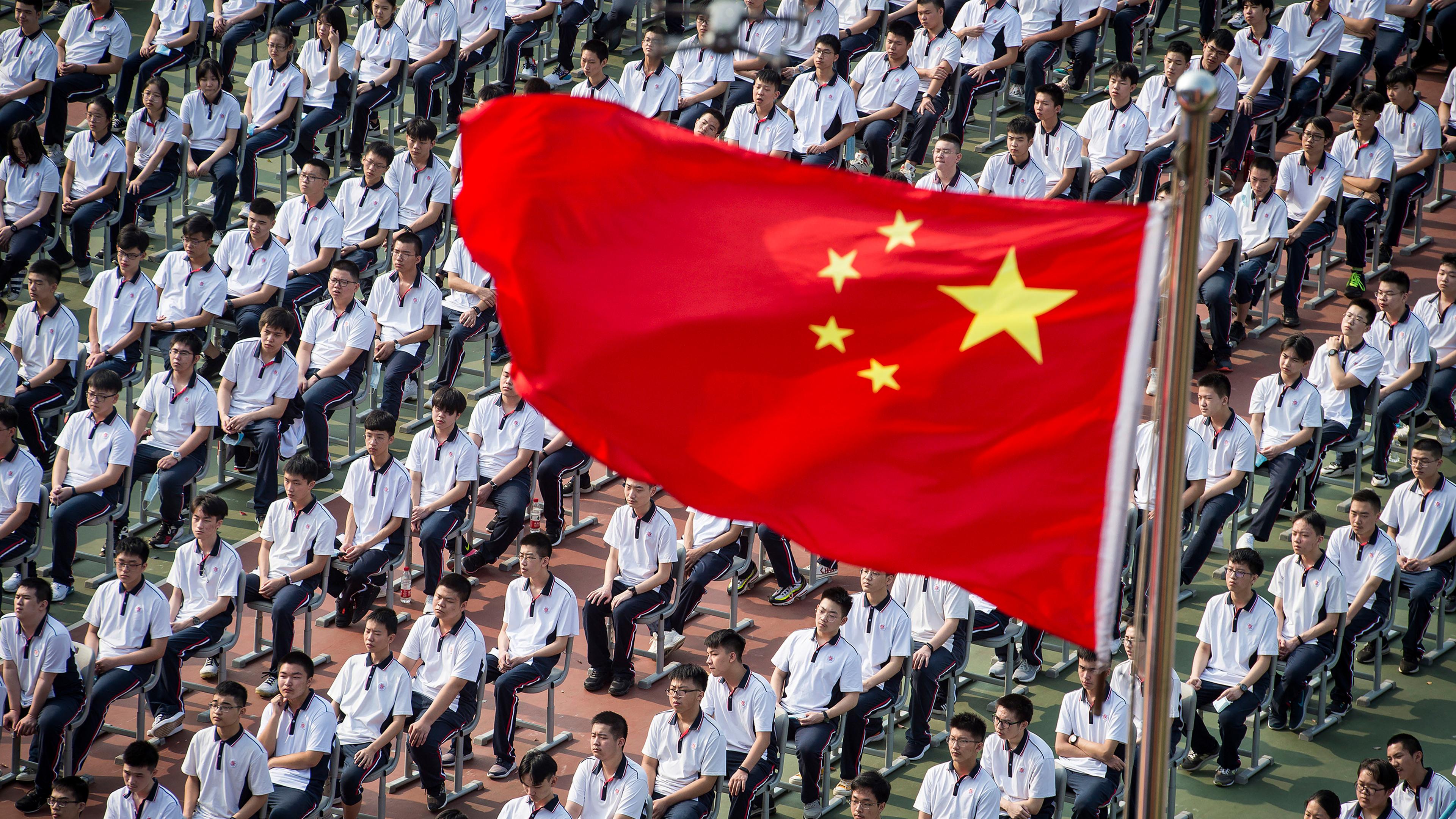 Man sieht aufmarschierende Soldaten. Darüber die chinesische Flagge.