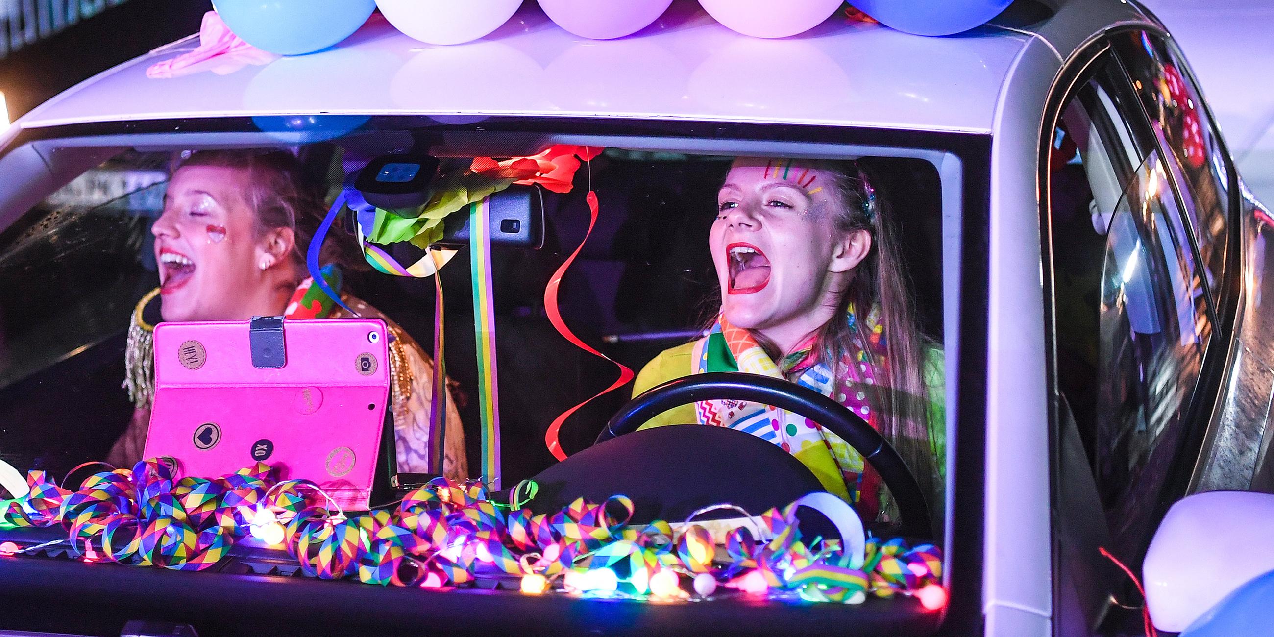 Teilnehmerinnen in ihrem Auto bei einem Karnevalskonzert in einem Bonner Autokino.