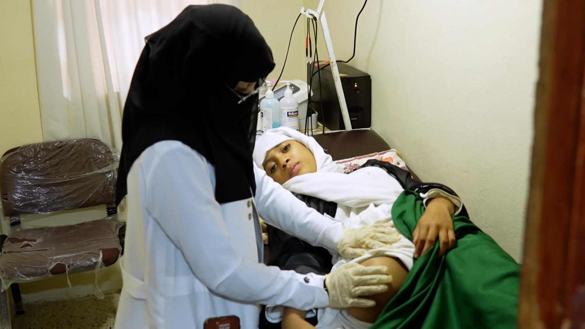 Eine Ärztin behandelt ein Mädchen, welches sein Bein verloren hat. 