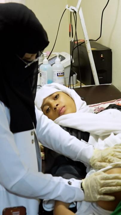 Eine Ärztin behandelt ein Mädchen, welches sein Bein verloren hat. 