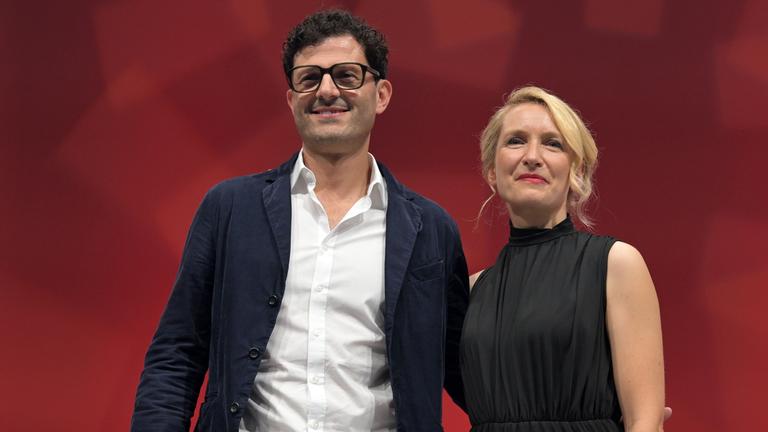Luigi Pantisano und Ines Schwerdtner, die neue Doppelspitze der Linken, stehen in der Metropolis Halle in Potsdam.
