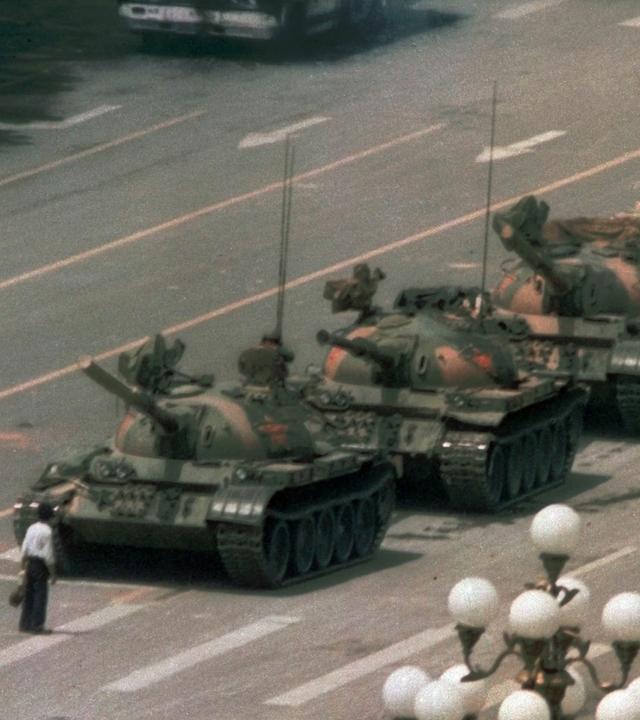 Ein chinesischer Mann steht allein, um eine Linie von Panzern zu blockieren, die auf Changan Boulevard Pekings nach Osten vorangehen.