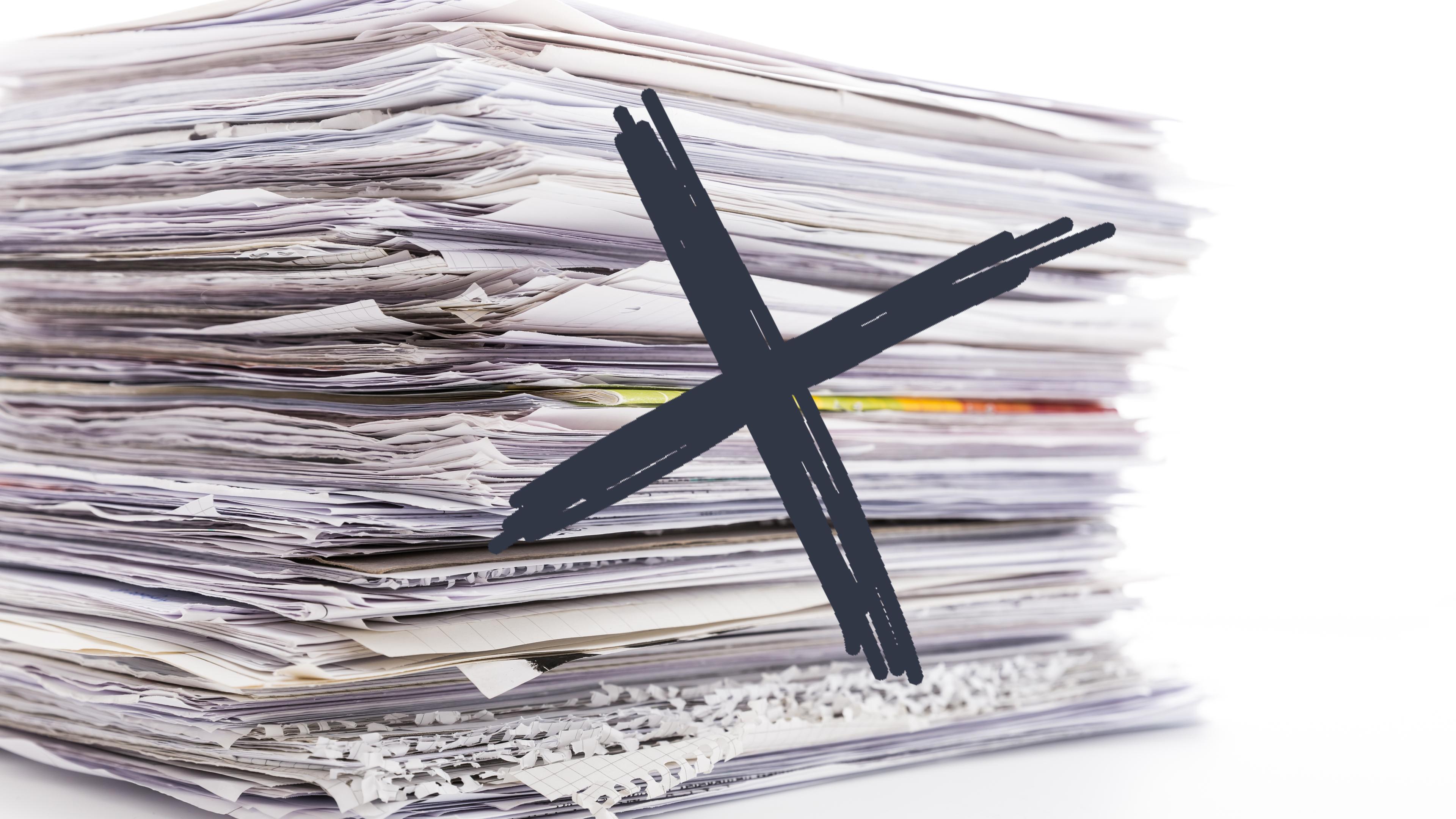 Ein Papierstapel mit einem Kreuz drauf 