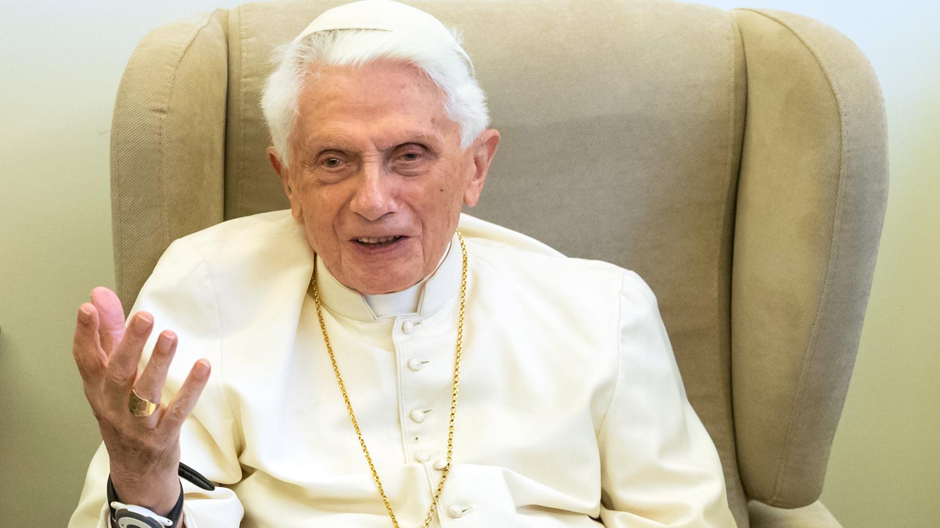 Papst Benedikt sitzt auf einem Sessel und gestikuliert