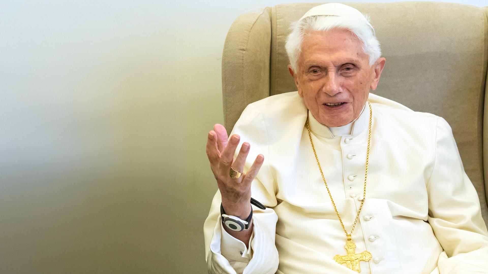 Papst Benedikt sitzt auf einem Sessel und gestikuliert