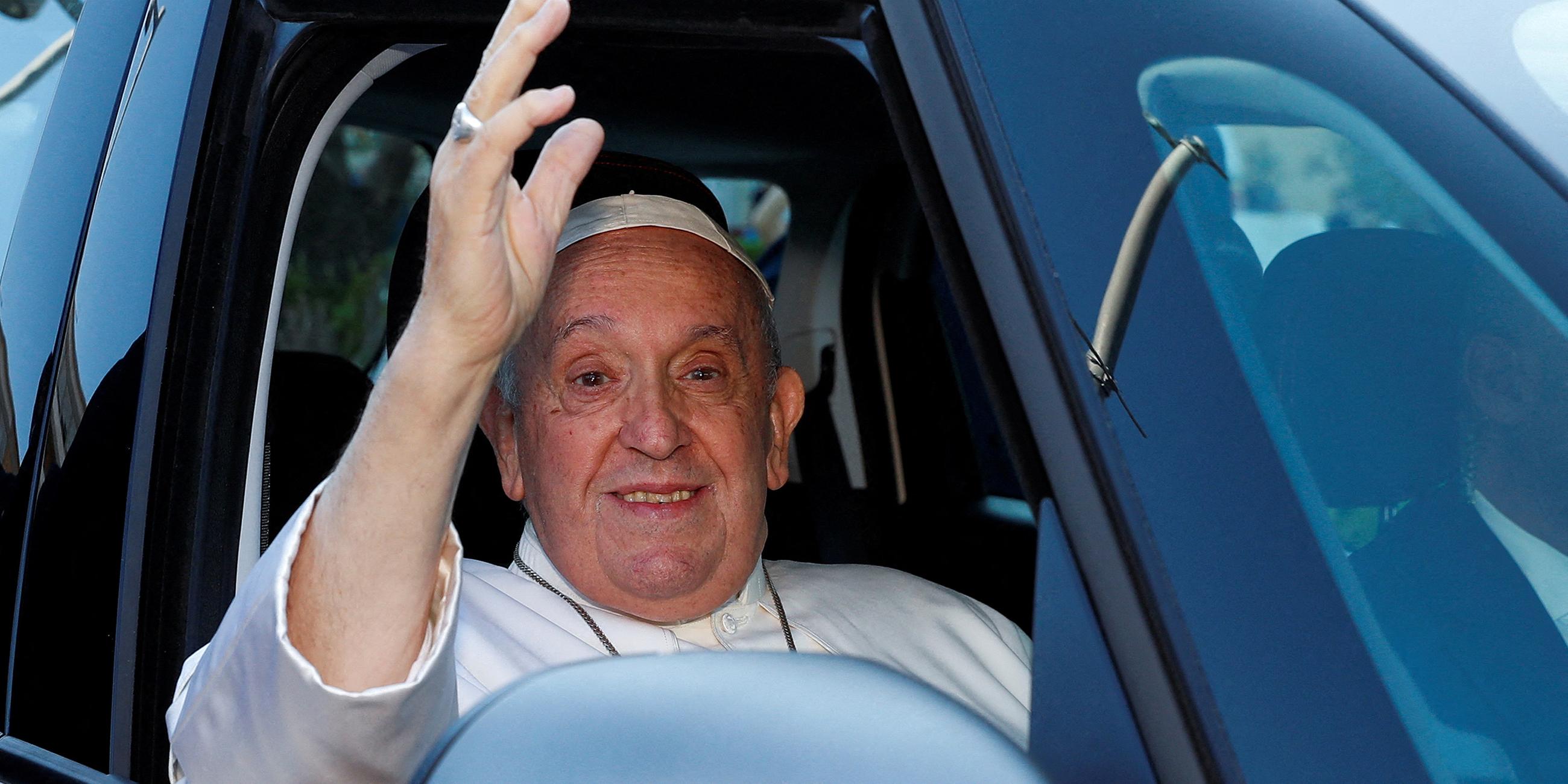 Papst Franziskus winkt aus einem Auto