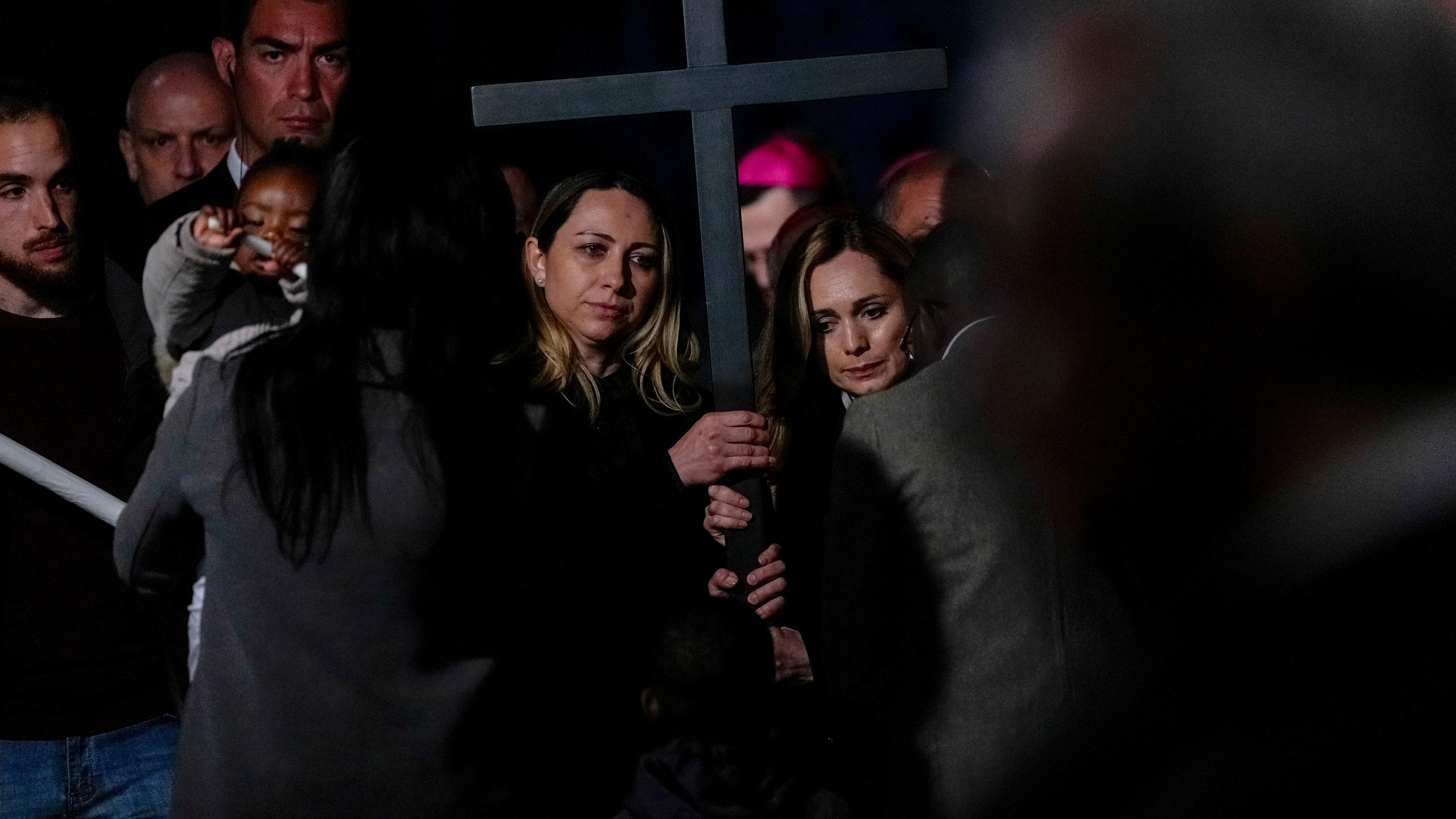 Zwei Krankenschwestern aus Russland und der Ukraine tragen das Kreuz gemeinsam, als sie Kreuzweg gehen.