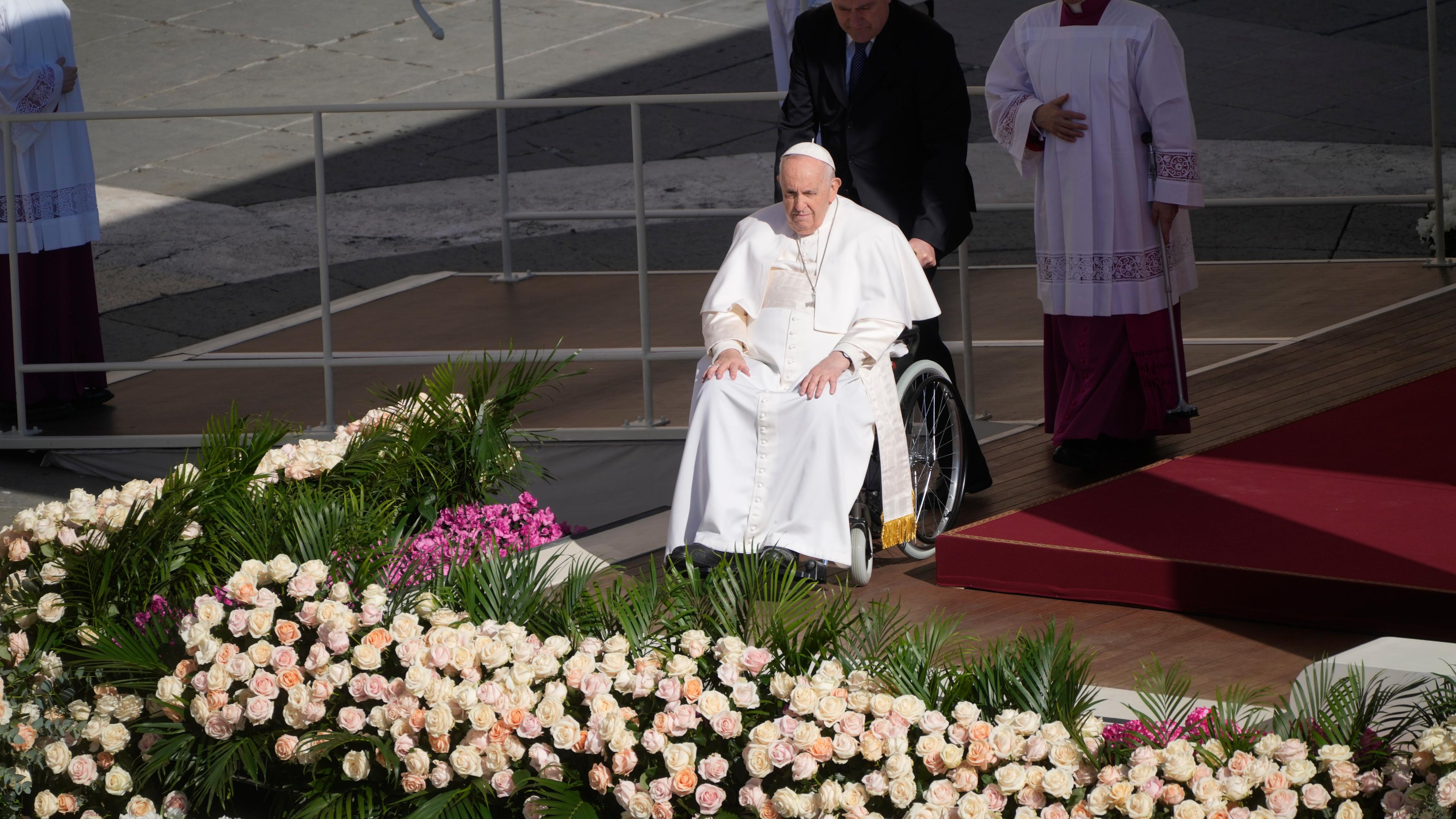 Papst Franziskus kommt in einem Rollstuhl auf den Petersplatz