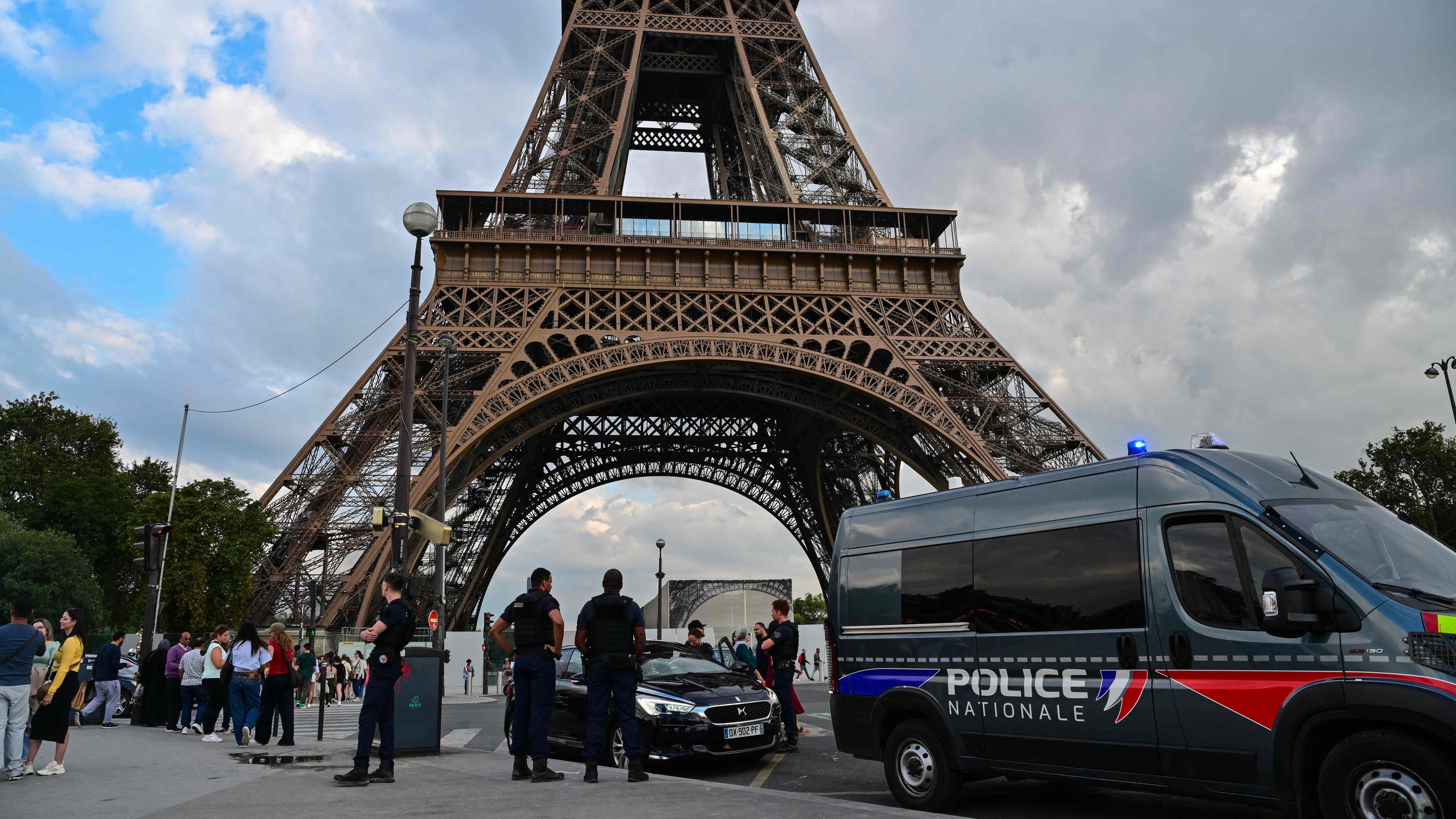 Ein Polizeiauto steht am Fuße des Eiffelturms.