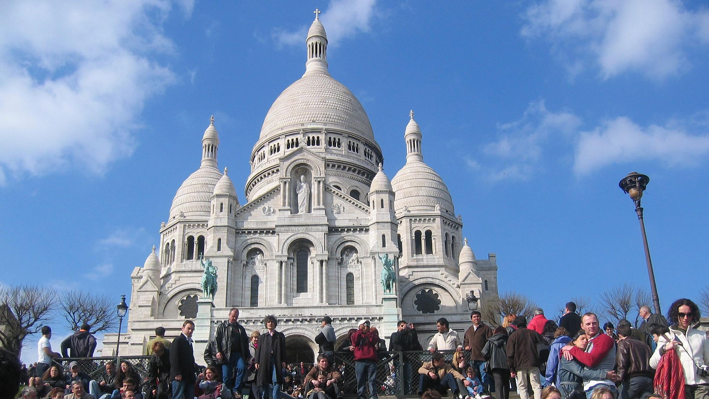 Hunderte Touristen und Besucher sitzen auf der Treppe vor der Kirche Sacre Coeur auf dem Hügel Montmartre in Paris