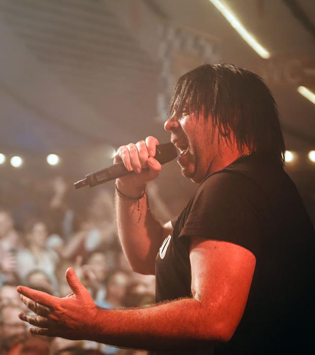 Ikke Hüftgold singt vor Publikum auf einer Bühne bei einem Dorffest.