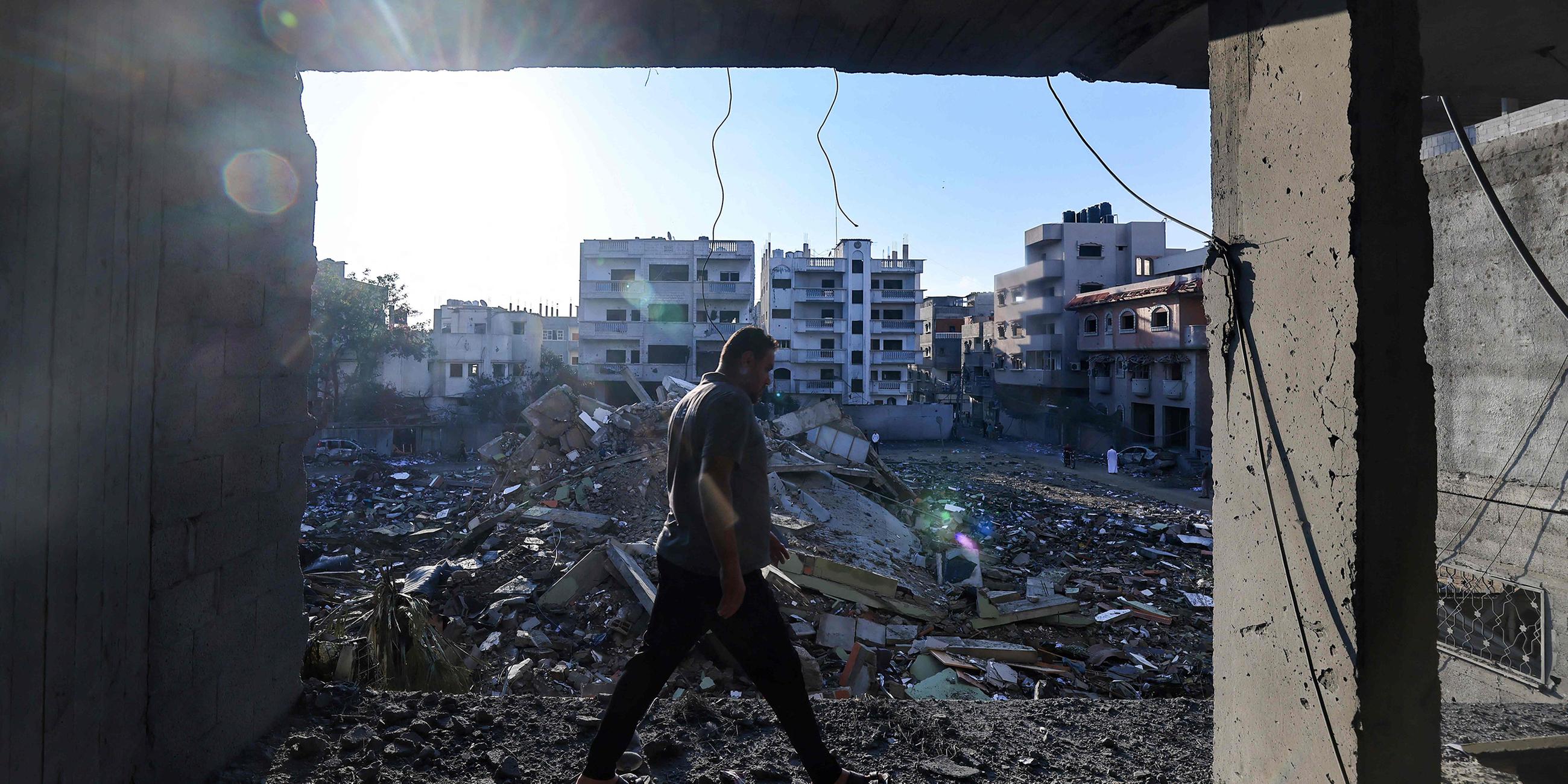 Ein Mann läuft durch zerstörte Gebäude in Rafah