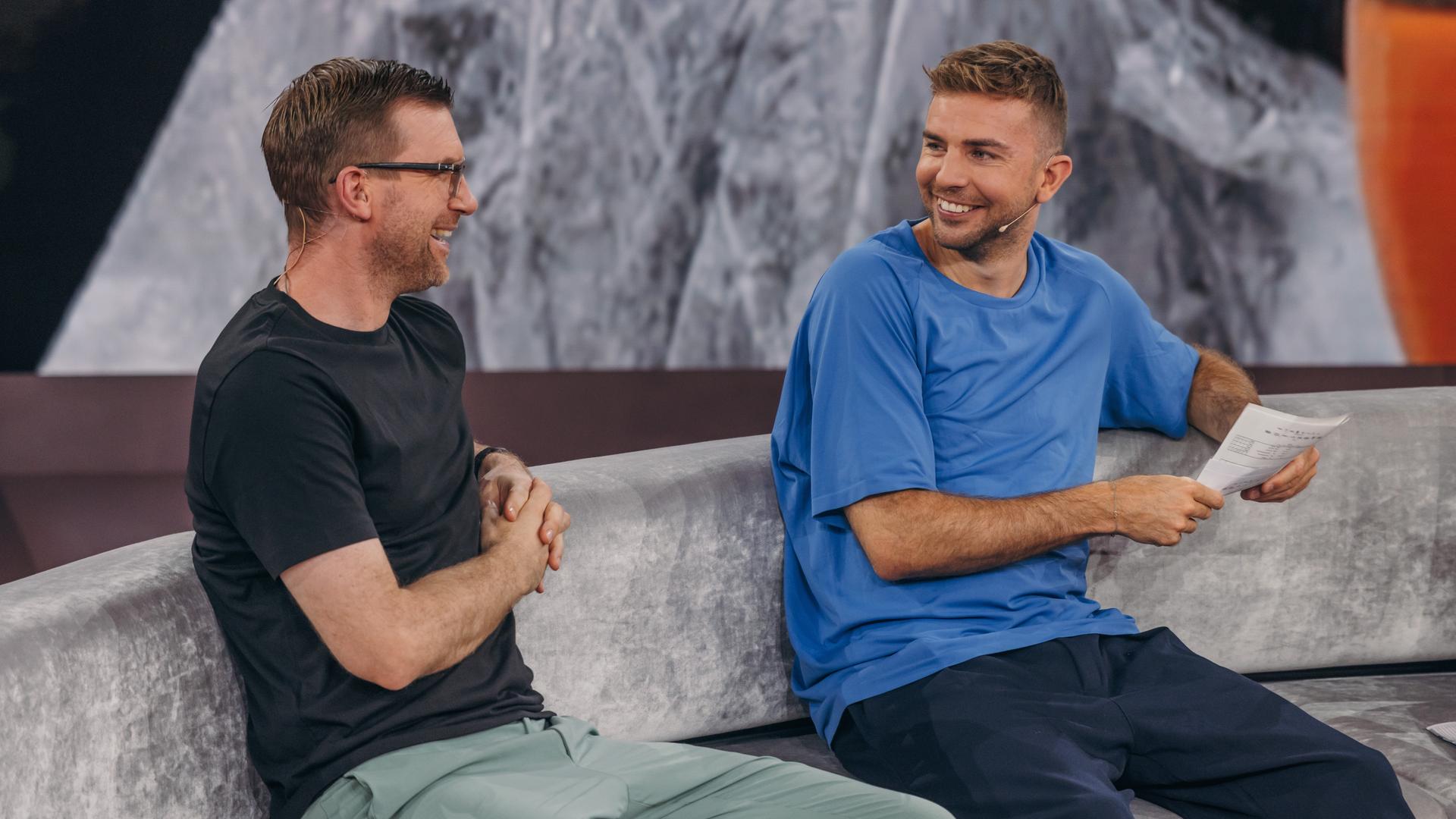 Per Mertesacker und Christoph Kramer lachen sich auf dem Sofa im WM-Studio an. 