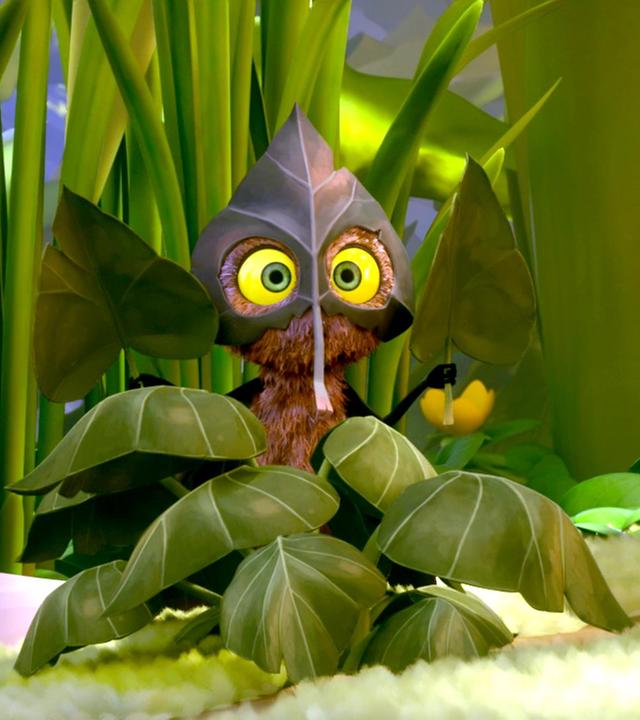 Incognito versteckt sich in einem Blätterhaufen, aber er ist trotzdem gut zu sehen. In den Händen hält er jeweils ein Blatt.