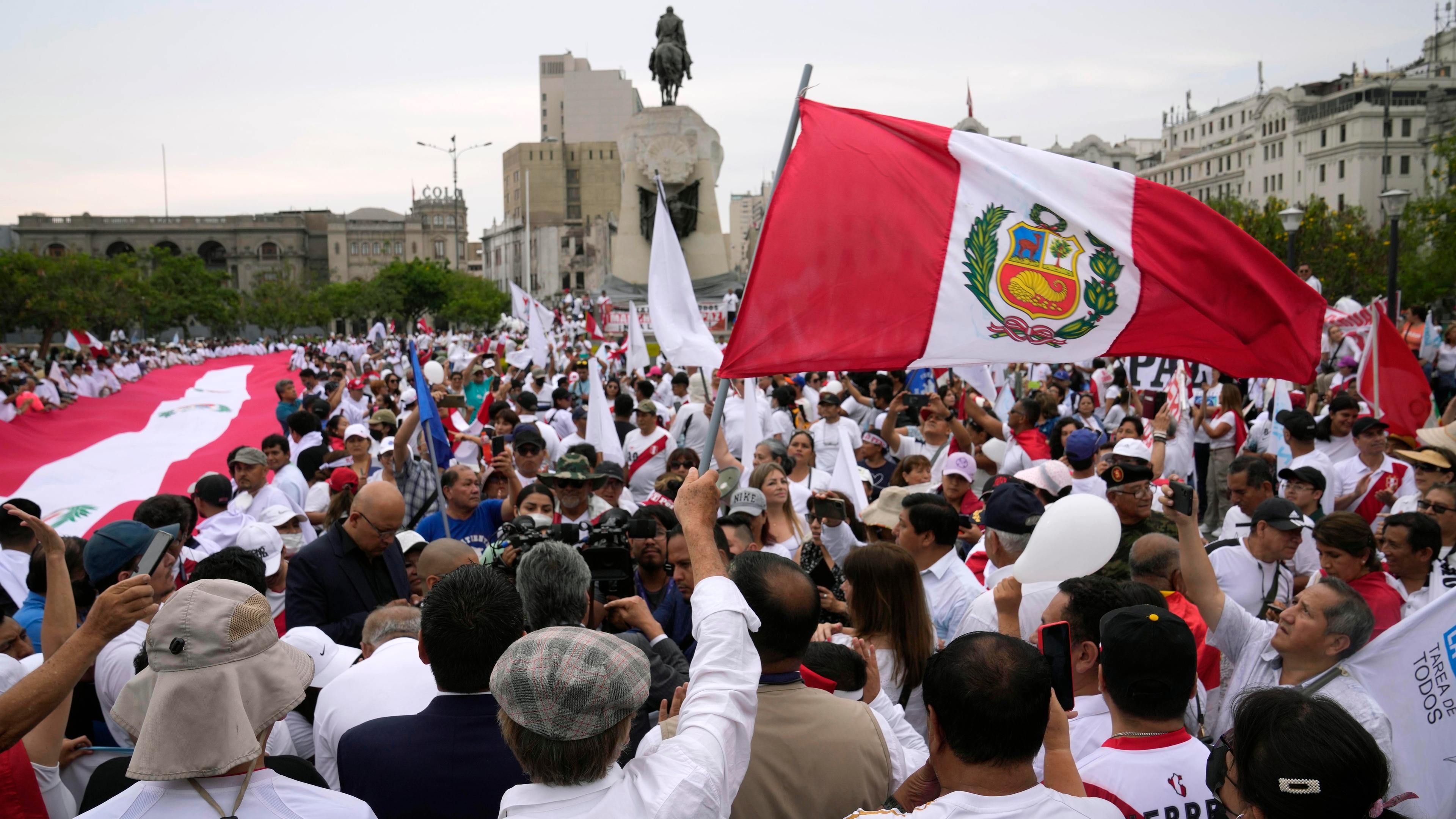 Demonstranten in Peru schwenken peruanische Flaggen.