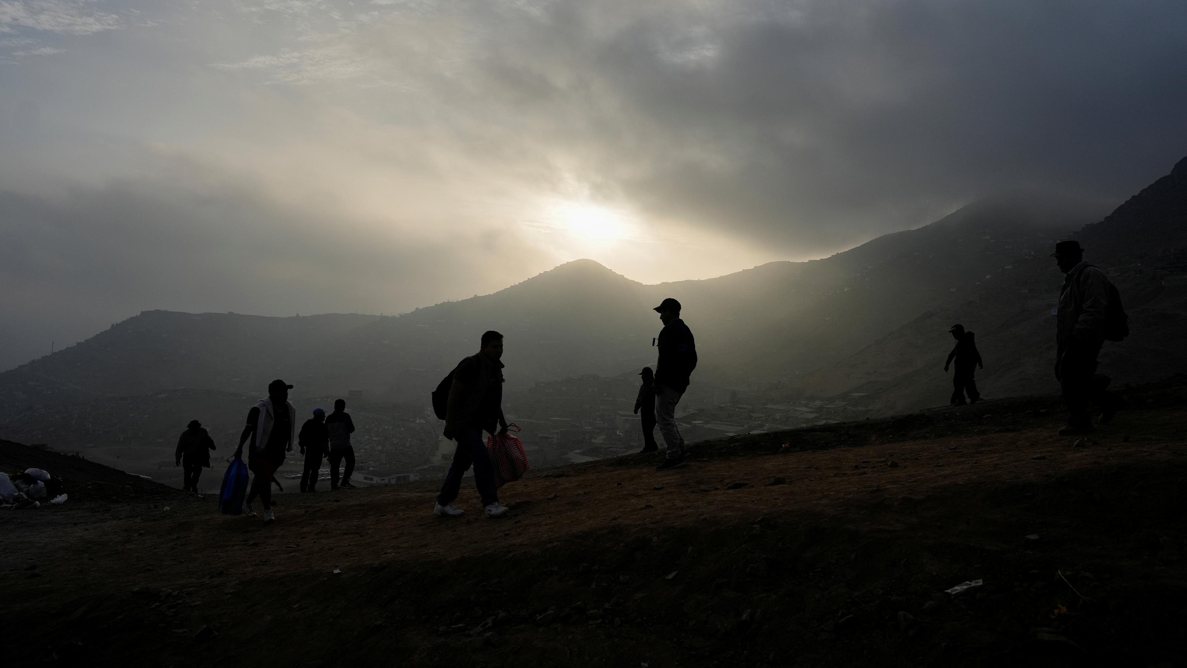 Menschen gehen einen Berg hoch in Peru.