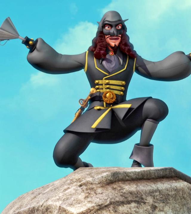 Der ganz in schwarz und mit Maske gekleidete El Hookato steht auf einem Felsen. Er reißt seine Arme hoch und hält eine erschreckende Pose inne.