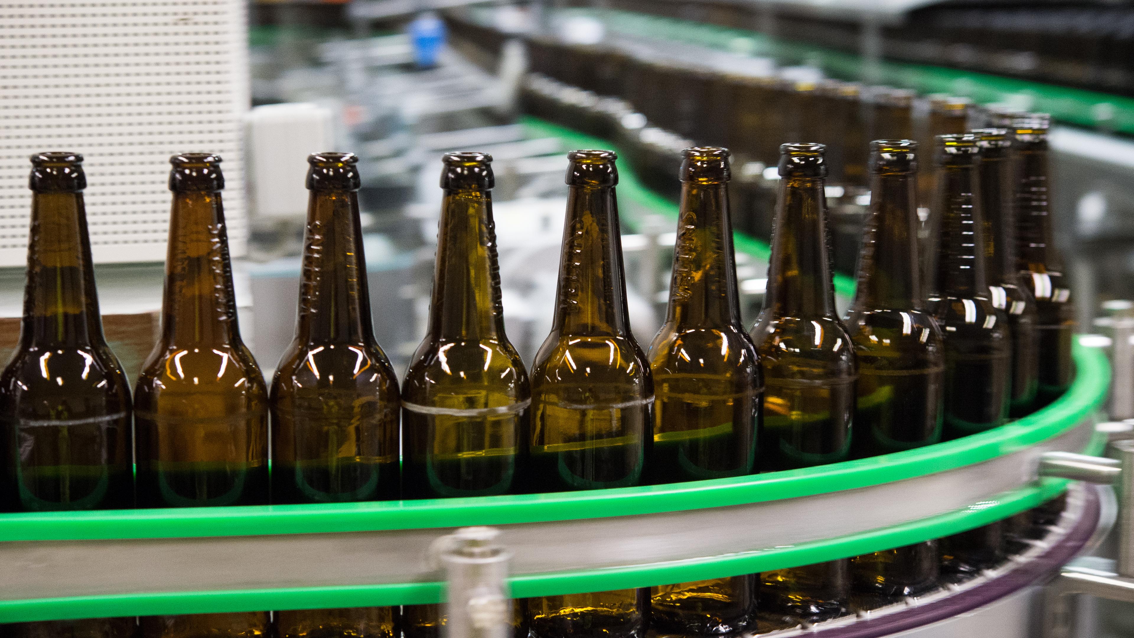 Gewaschene bierflaschen laufen durch die Produktion einer Brauerei.
