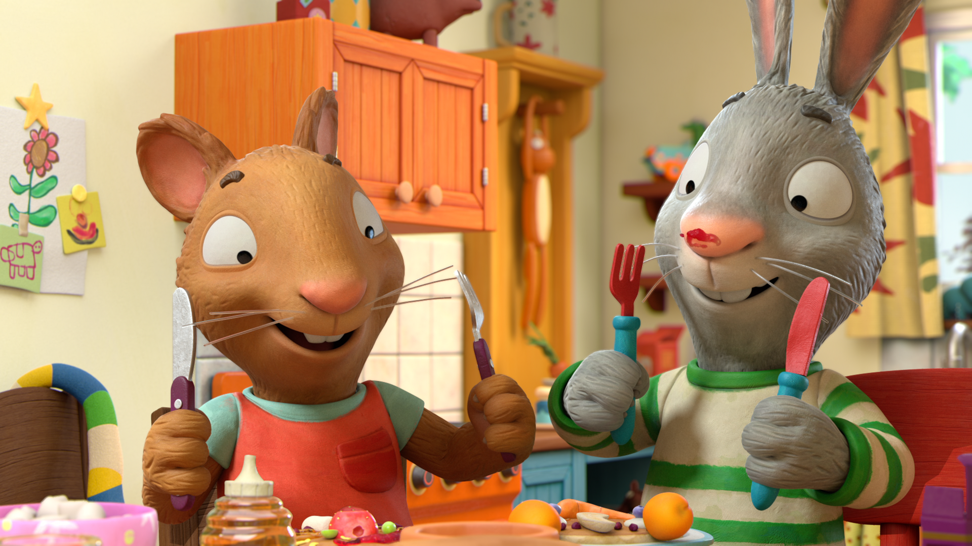 In der Küche: Posy, die Maus, und ihr bester Freund Pip, das Kaninchen, stehen nebeneinander. Beide haben Gabel und Messer in ihren Händen und machen sich freudig dreinblickend bereit ihre leckeren Pfannkuchen, die vor ihnen stehen, zu essen. Pip hat auf seiner Nase einen roten Marmeladenklecks.