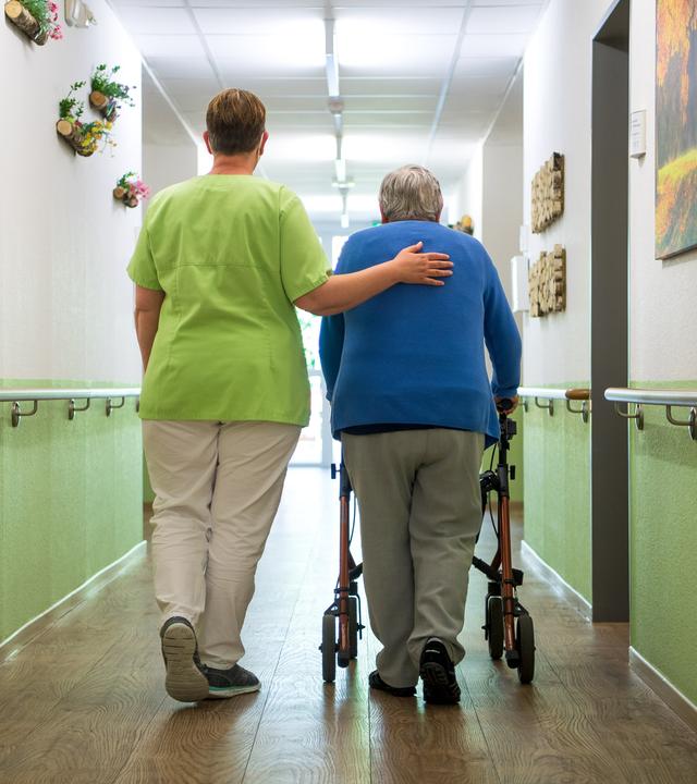 Eine Pflegefachkraft geht mit einer Bewohnerin durch das Seniorenheim «Mein Zuhause Nienburg».