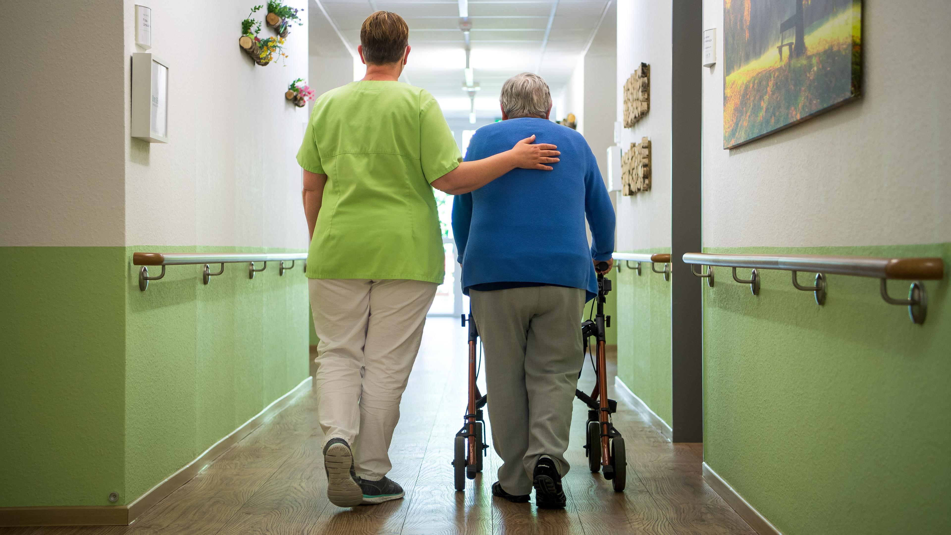 Eine Pflegefachkraft geht mit einer Bewohnerin durch ein Seniorenheim, aufgenommen am 16.06.2021 in Nienburg