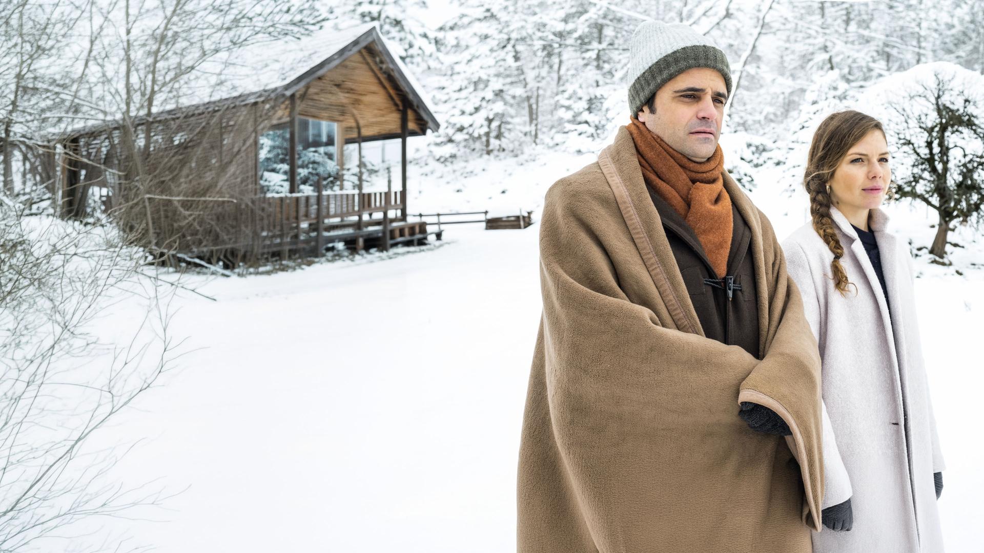 "Der Bergdoktor: Phantomschmerz (2)": Michael Rösler (Maximilian Grill) und Anna Hambichler (Leonie Rainer) laufen in einer verschneiten Landschaft nebeneinander her und unterhalten sich.