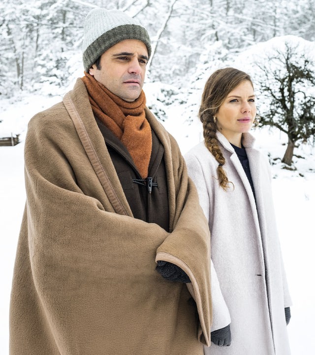 "Der Bergdoktor: Phantomschmerz (2)": Michael Rösler (Maximilian Grill) und Anna Hambichler (Leonie Rainer) laufen in einer verschneiten Landschaft nebeneinander her und unterhalten sich.