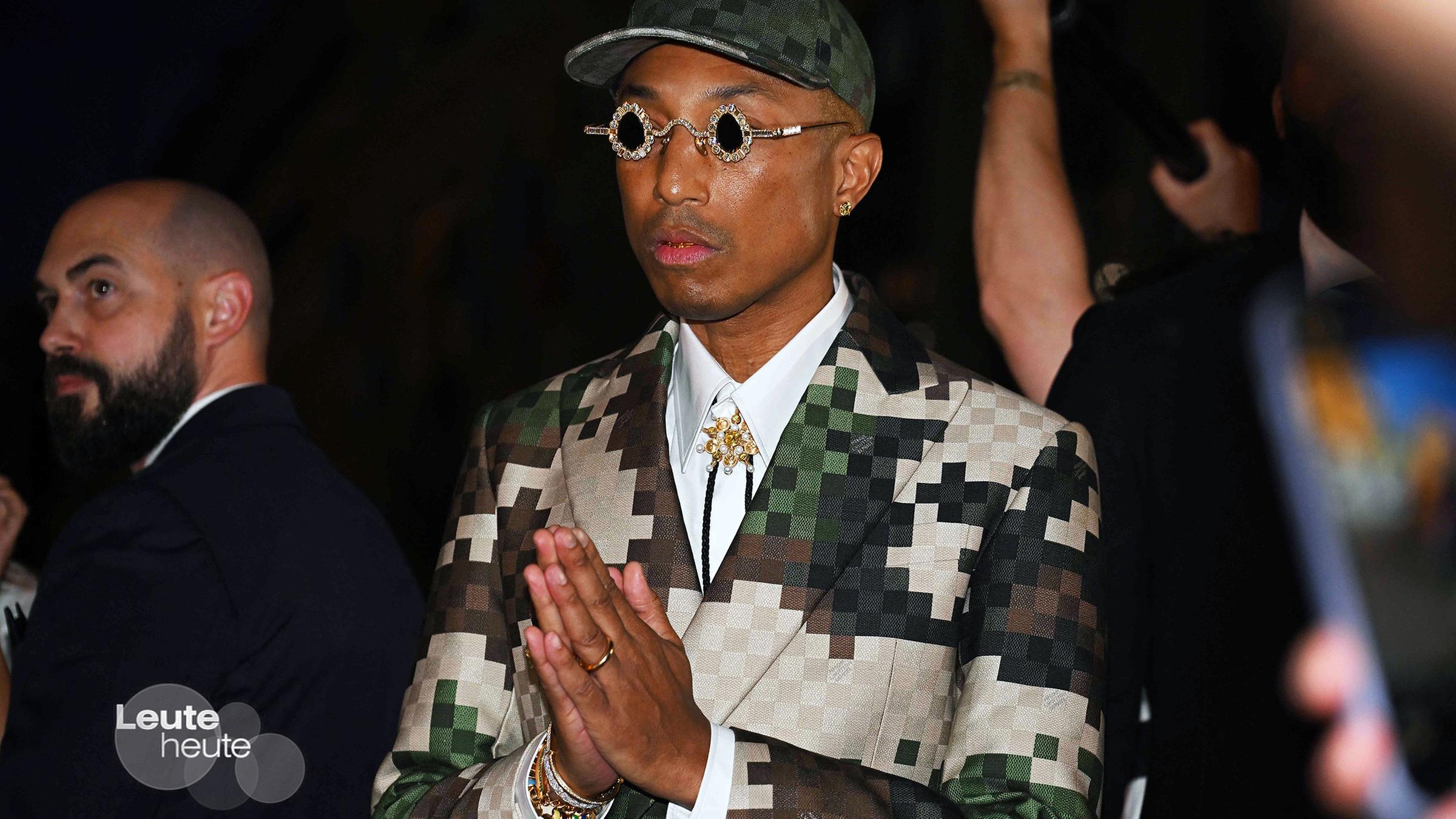 Sänger und Designer Pharrell Williams, mit Mini-Sonnebrille und wie zum Gebet gefalteten Händen. Komplett in Vuitton aus seiner ersten Kollektion.