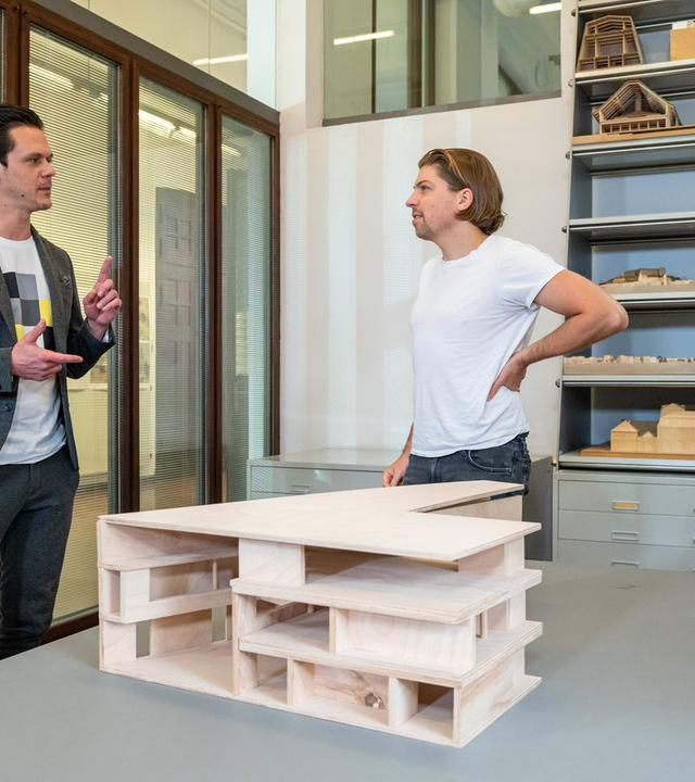 "zdf@bauhaus": Singer-Songwriter Philipp Poisel (rechts) im Interview mit Moderator Jo Schück (links). Im Hintergrund stehen Holz-Modelle im Regal. Vorne links ist ein Bildschirm, auf dem Philipp Poisel zu sehen ist.