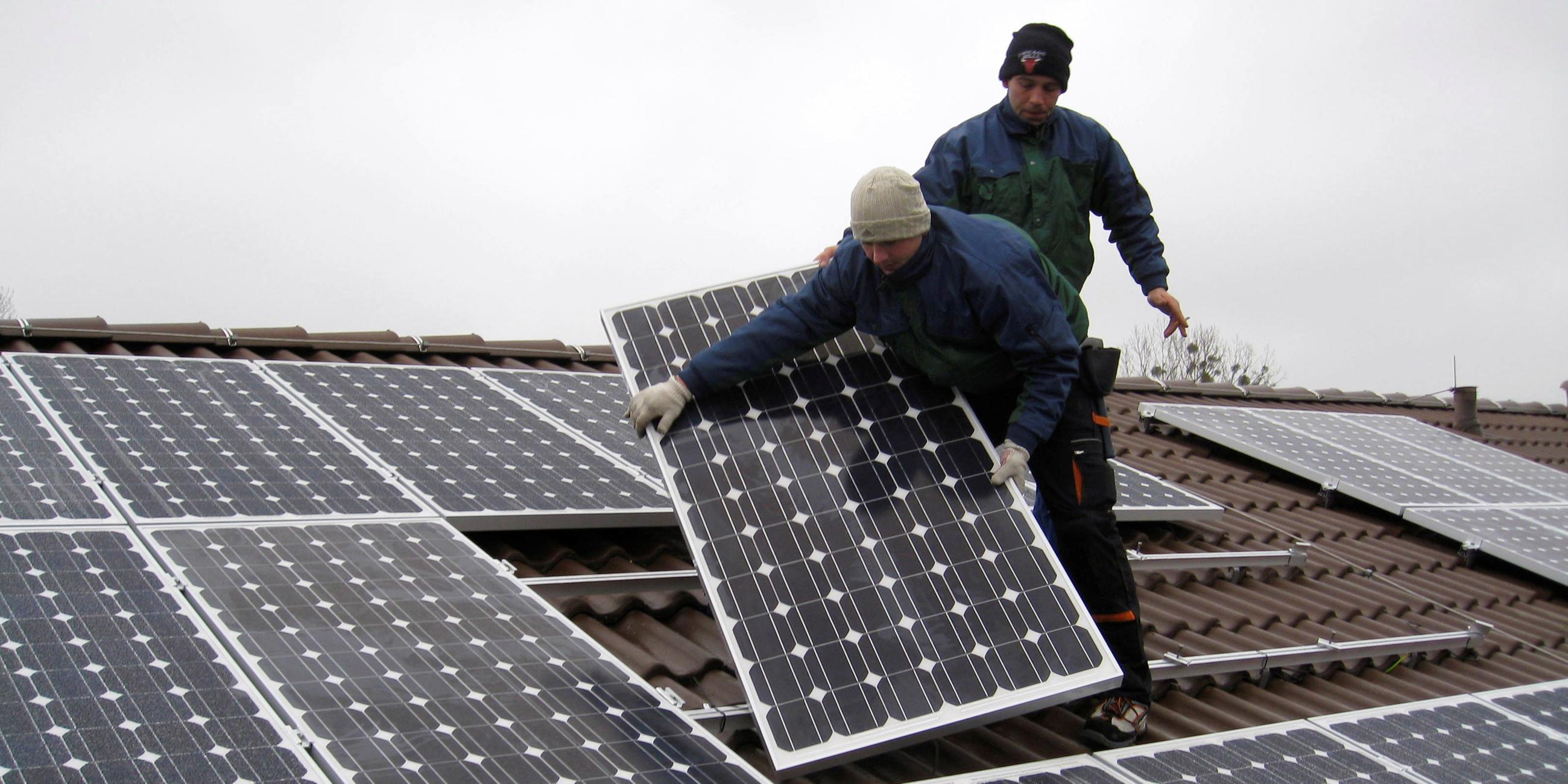 Berlin: Arbeiter installieren eine Photovoltaikanlage auf einem Dach in Falkensee. Archivbild