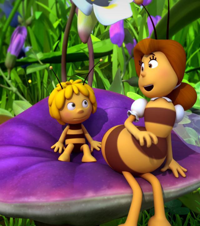 Frau Kassandra und Maja sitzen auf einer lilafarbenen Blume.