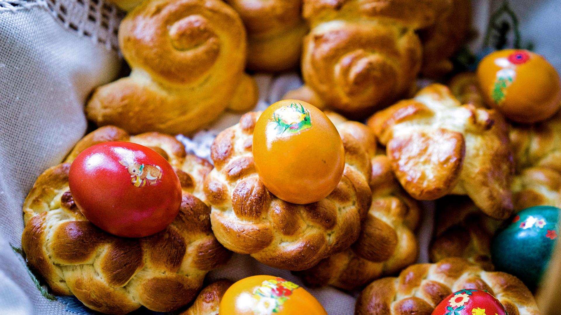 Mehrere kleine Osterkränze und bunte Eier.