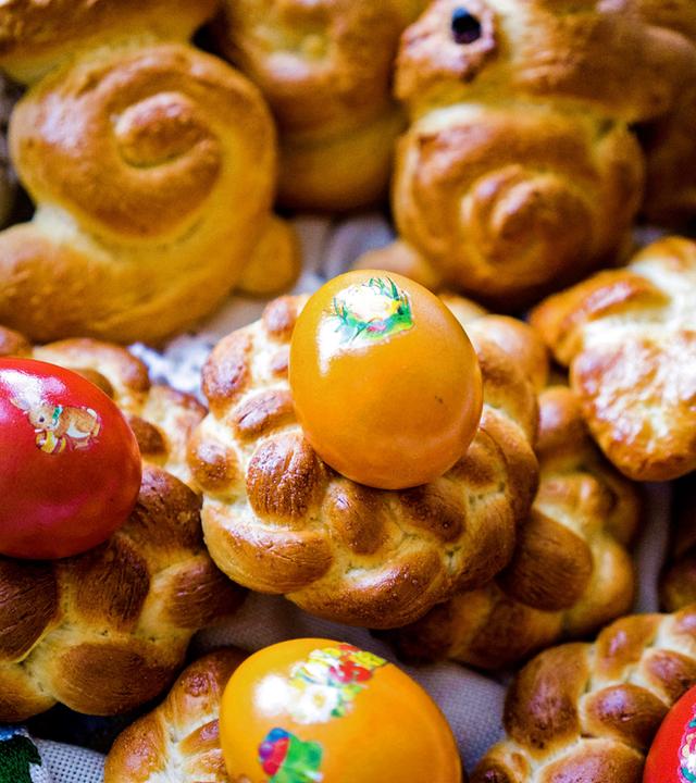 Mehrere kleine Osterkränze und bunte Eier.