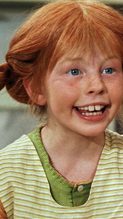 Pippi Langstrumpf schaut frechem Blick und weit aufgerissenem Mund.