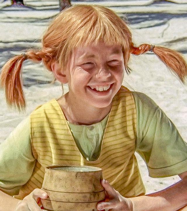 Pippi Langstrumpf sitzt auf einer Insel im Sand und hält ein kleines Pulverfaß in den Händen.