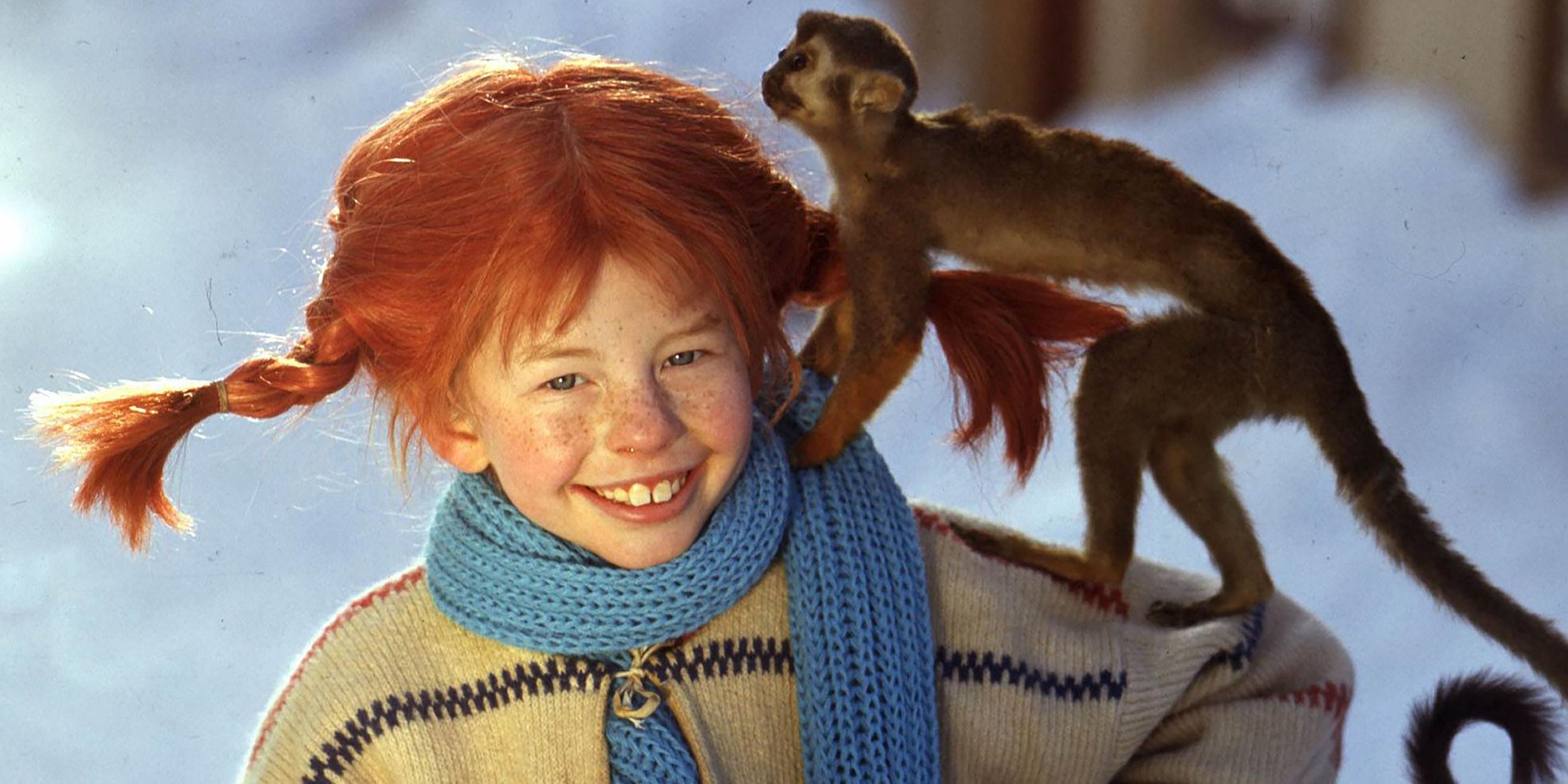 Pippi Langstrumpf (Inger Nilsson) steht im Schnee mit ihrem Affen Herr Nilsson auf dem Arm.