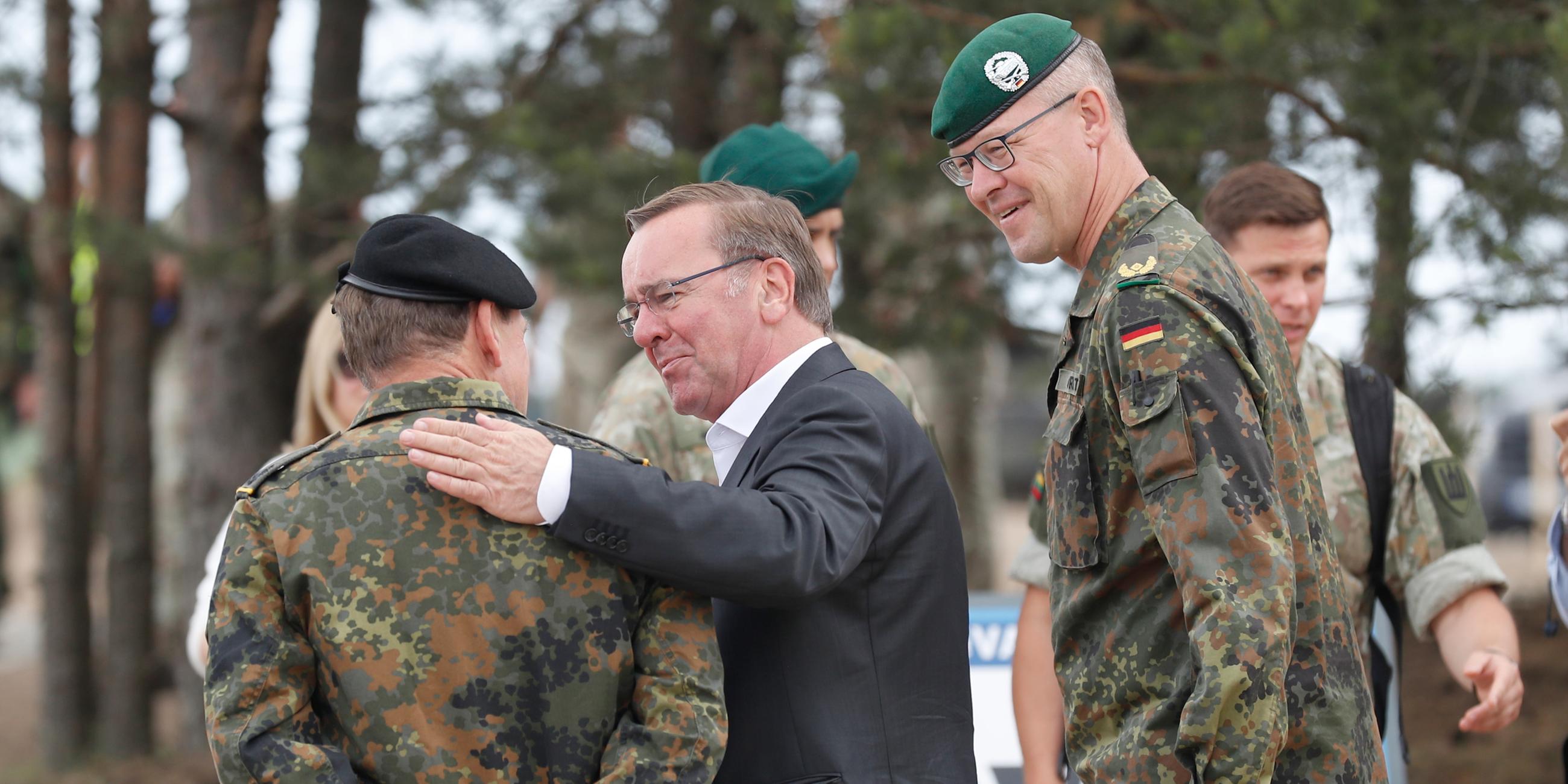 Der deutsche Verteidigungsminister Boris Pistorius spricht mit einem deutschen Offizier bei seiner Ankunft auf dem Truppenübungsplatz in Pabrade